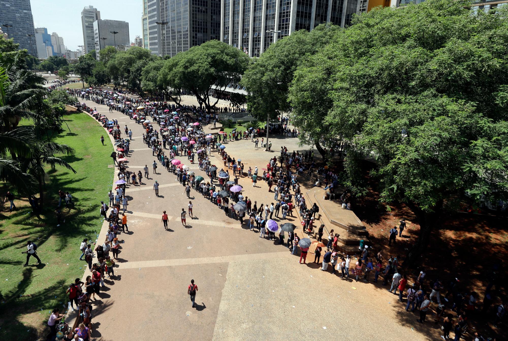Cientos de personas desempleadas hacen fila para asistir a una feria de trabajo organizada por el gobierno local y un sindicato, en el centro de Sao Paulo, Brasil, el martes 26 de marzo de 2019. 