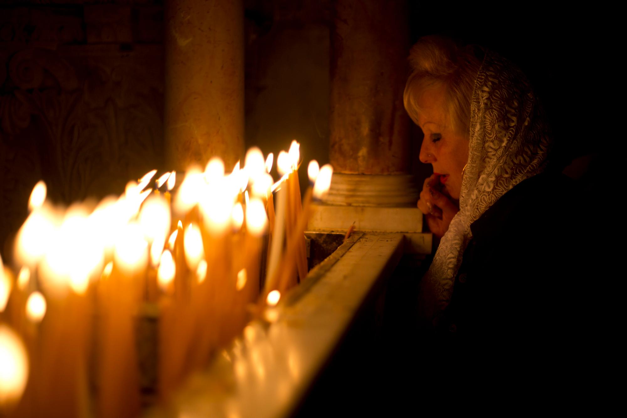 Una mujer cristiana ora en la Iglesia del Santo Sepulcro, tradicionalmente considerada por muchos como el lugar de la crucifixión de Jesucristo, durante la procesión de la semana santa en la ciudad vieja de Jerusalén, el sábado 20 de abril de 2019.