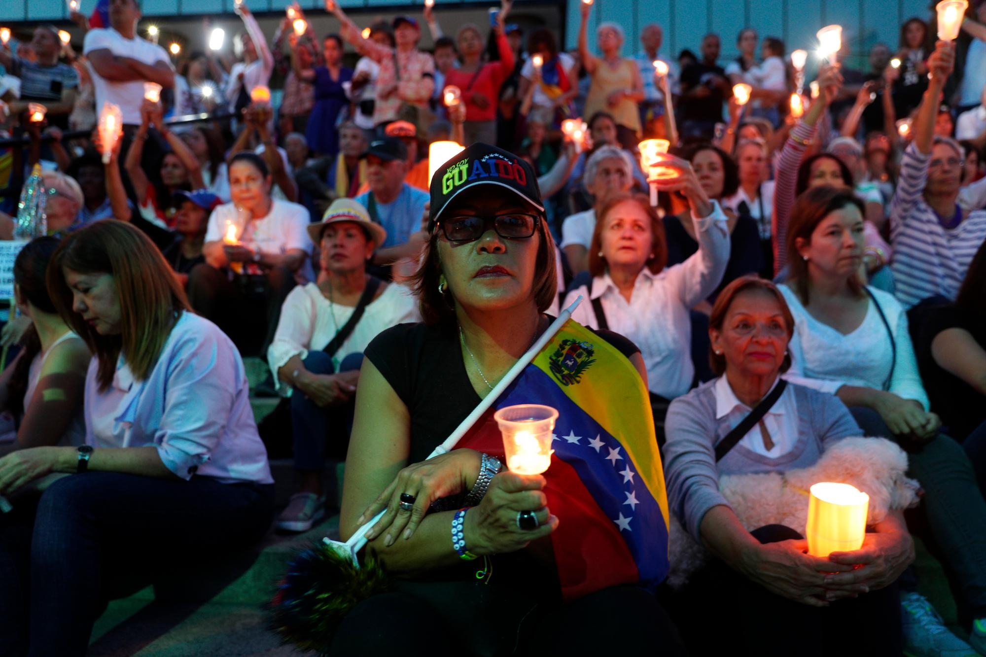 Opositores al presidente de Venezuela, Nicolás Maduro, tienen una vigilia por los muertos en las peleas callejeras durante la semana pasada en Caracas, Venezuela.