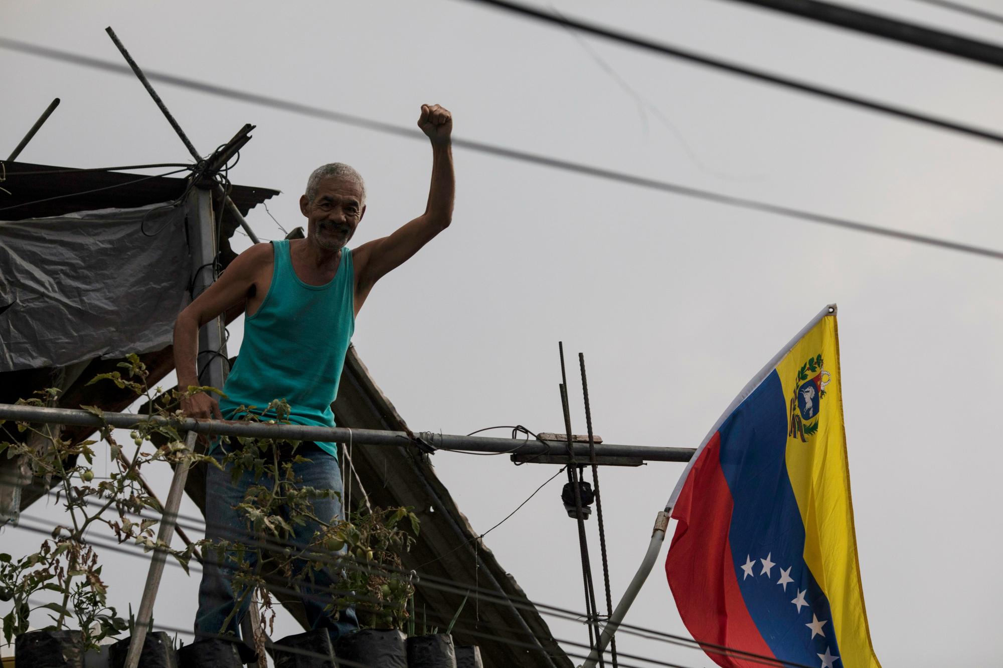Un hombre sostiene su puño para mostrar apoyo al Gobierno del presidente Nicolás Maduro, desde su balcón en Caracas, Venezuela, al atardecer del sábado 11 de mayo de 2019.