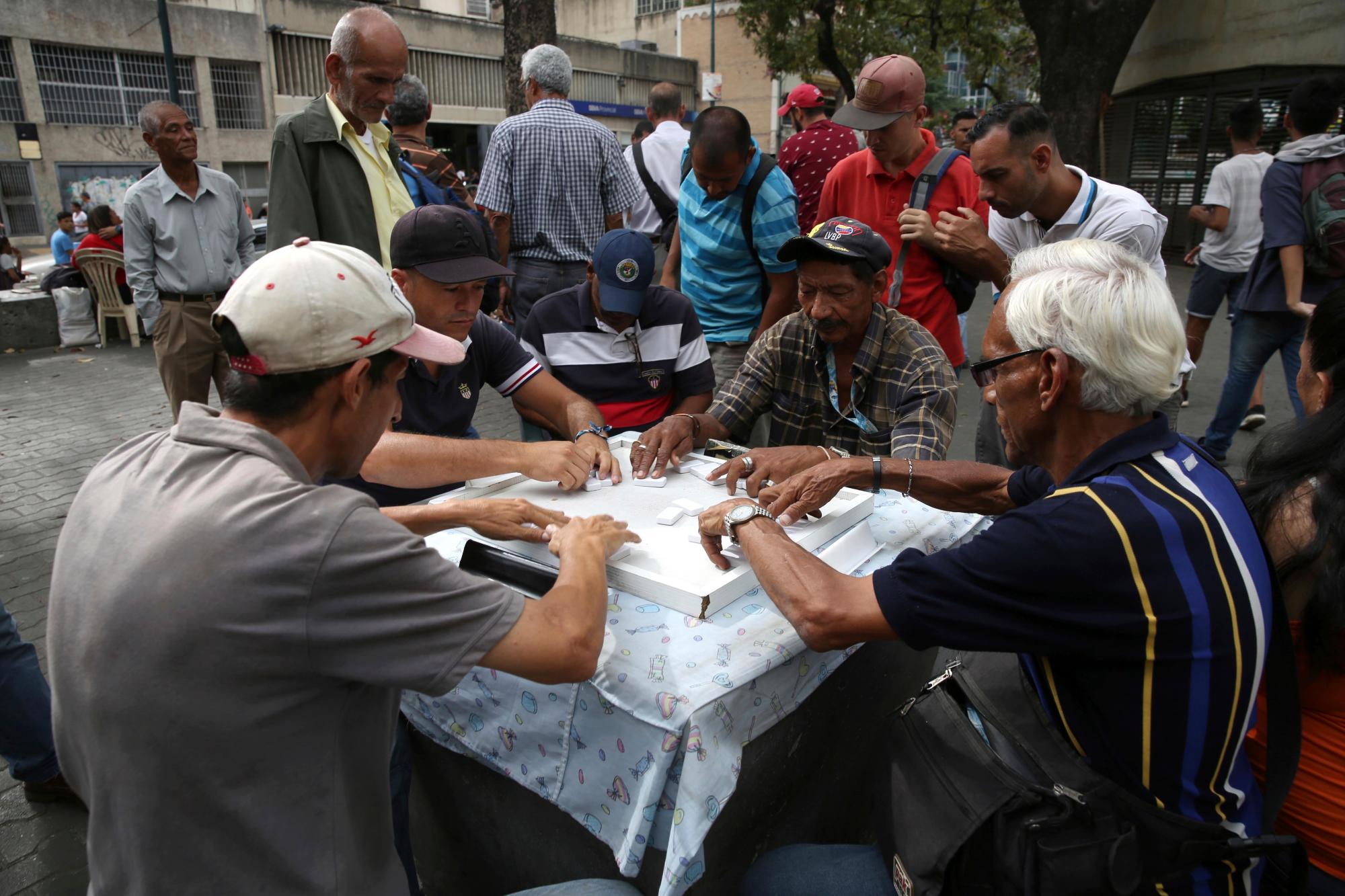 Los hombres juegan al dominó en la Plaza de Candelaria en Caracas, Venezuela, el lunes 13 de mayo de 2019.