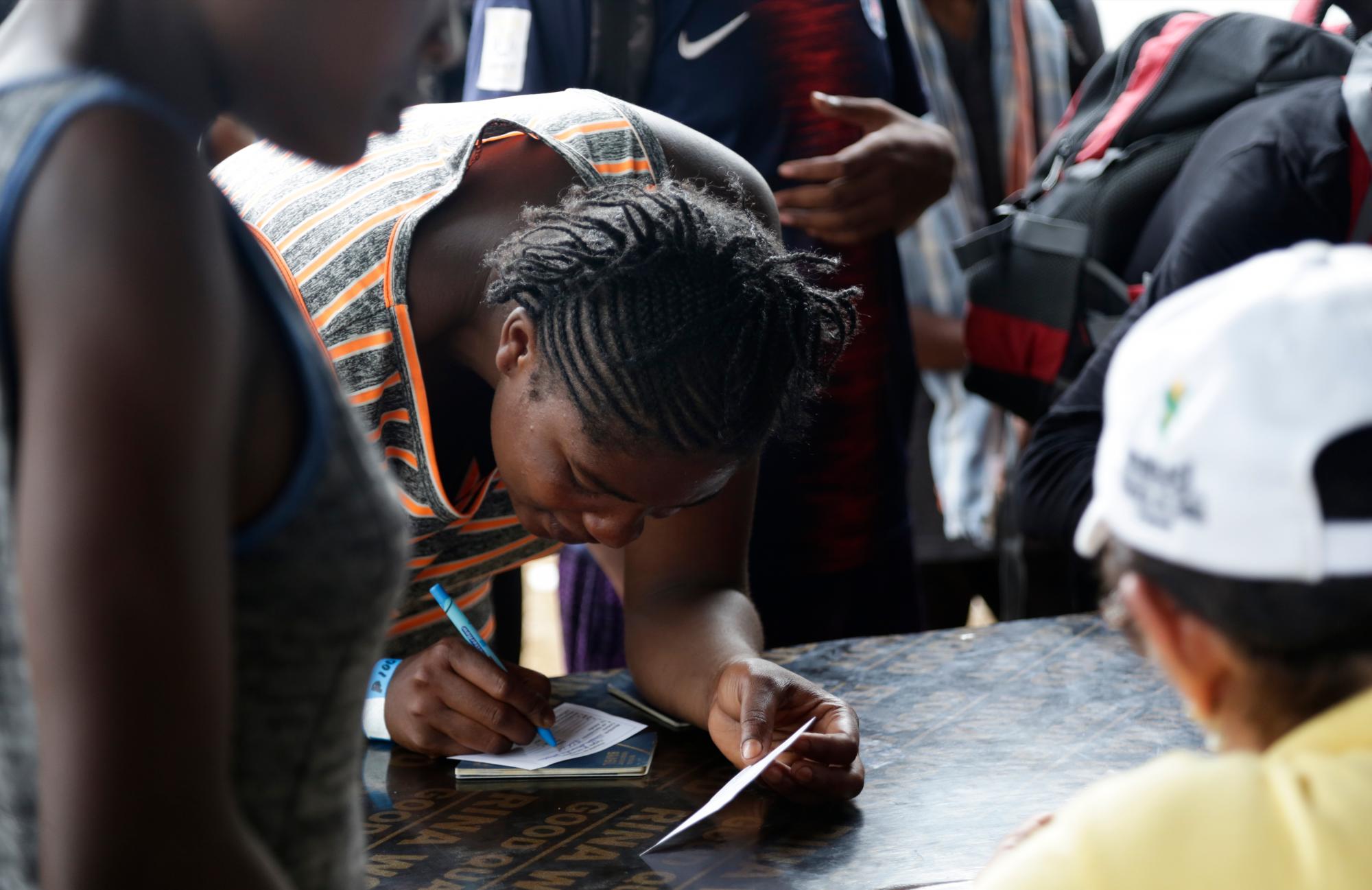 Una migrante firma un documento después de ser vacunado en Peñitas, provincia de Darien, Panamá. Los funcionarios vacunan a los migrantes contra el sarampión, el tétanos y la rubéola y hacen comprobaciones de antecedentes como medida de seguridad antes de transportarlas al oeste. 