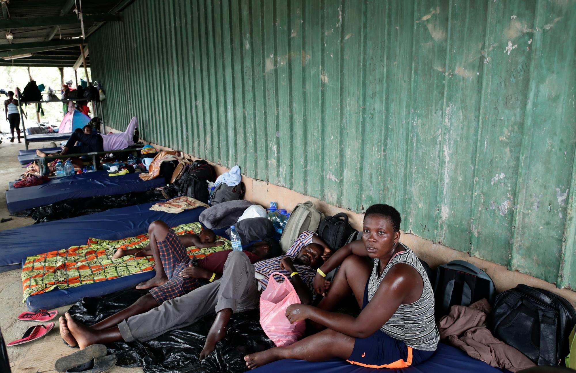 Migrantes de varios países africanos descansan en colchonetas delante de un granero utilizado como refugio en Peñitas, en la provincia de Darién, Panamá.