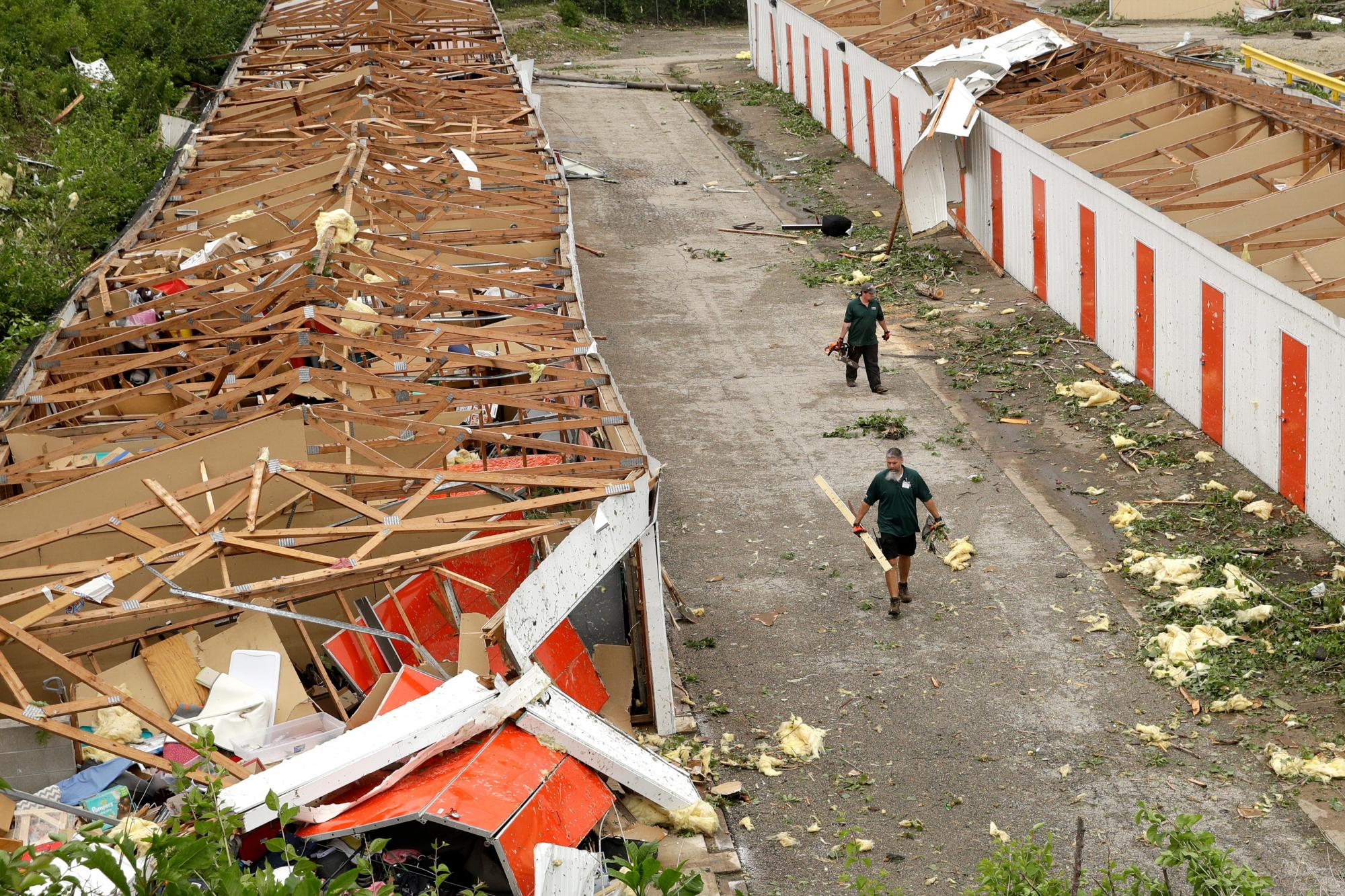 Workers pick up debris at destroyed storage units Thursday, May 23, 2019 after a tornado tore though Jefferson City, Mo. late Wednesday. (