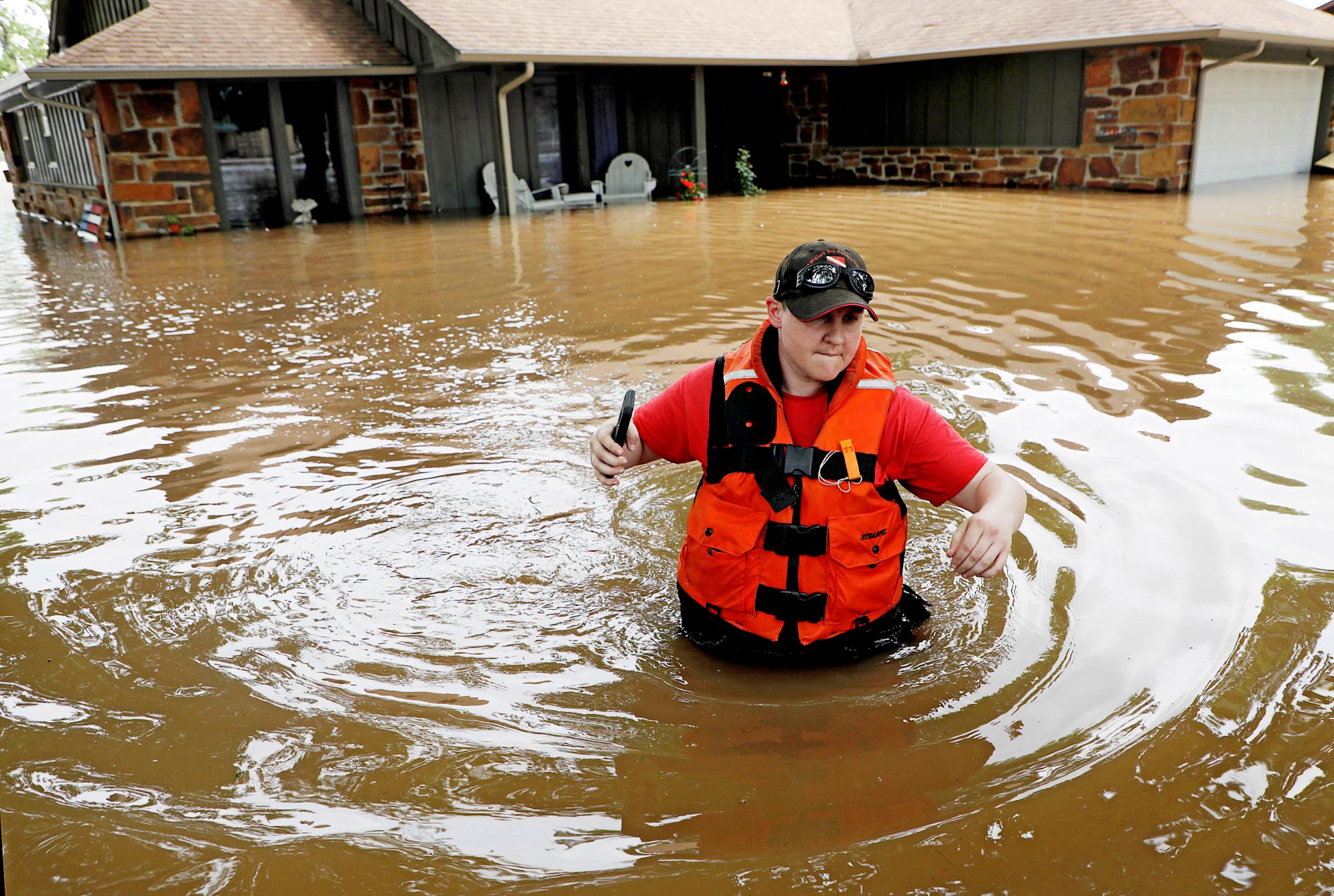 La ayudante del Sheriff del Condado de Tulsa, Miranda Munson, procede a revisar casas inundadas de los ocupantes del barrios de la ciudad y del campo en Sand Springs, Okla., jueves, 23 de mayo, 2019.
