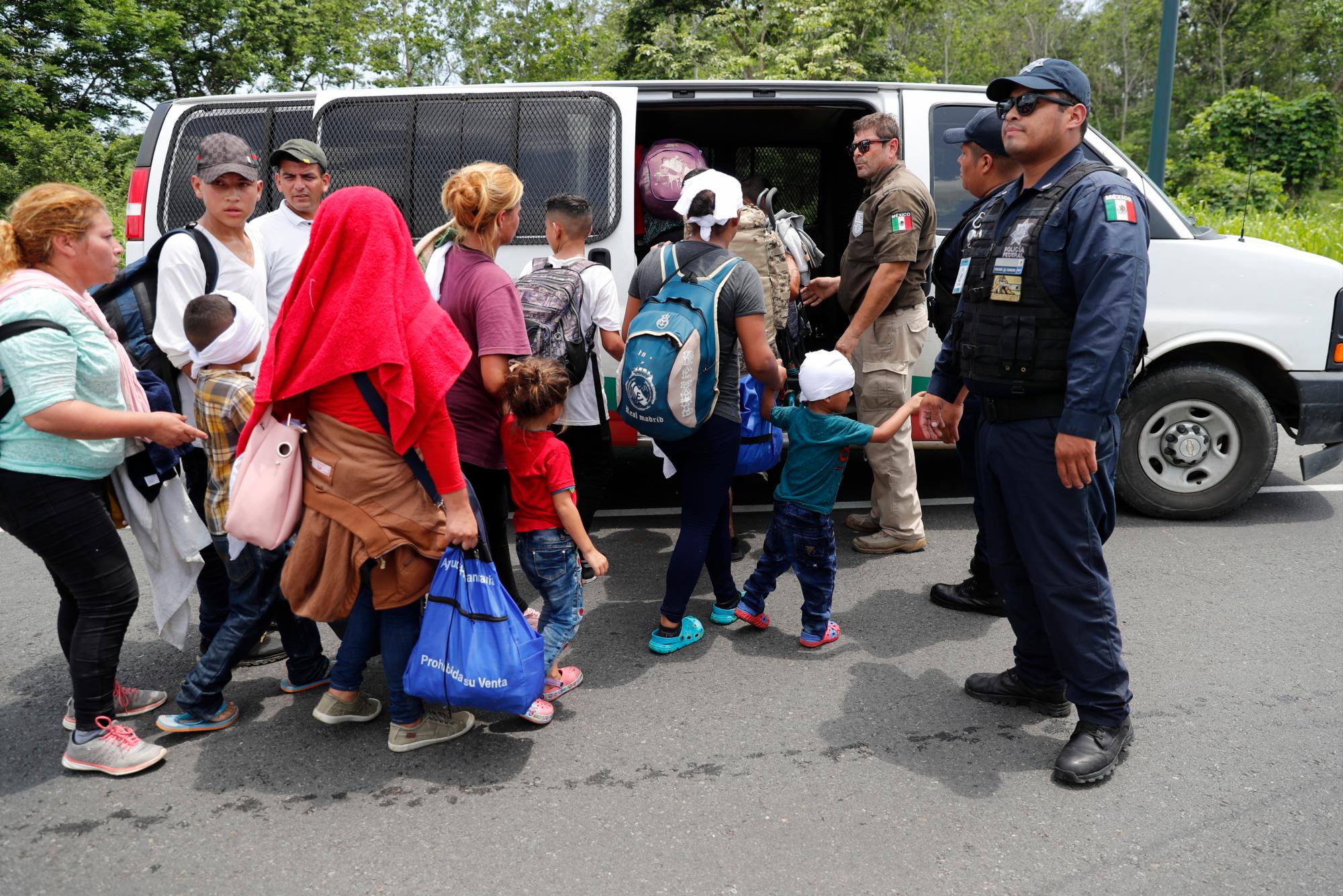 Los migrantes son cargados en una furgoneta por las autoridades de inmigración mexicanas durante un asalto a una caravana migrante que había cruzado anteriormente la frontera entre México y Guatemala, cerca de Metapa, estado de Chiapas, México, miércoles, 5 de junio de 2019. 