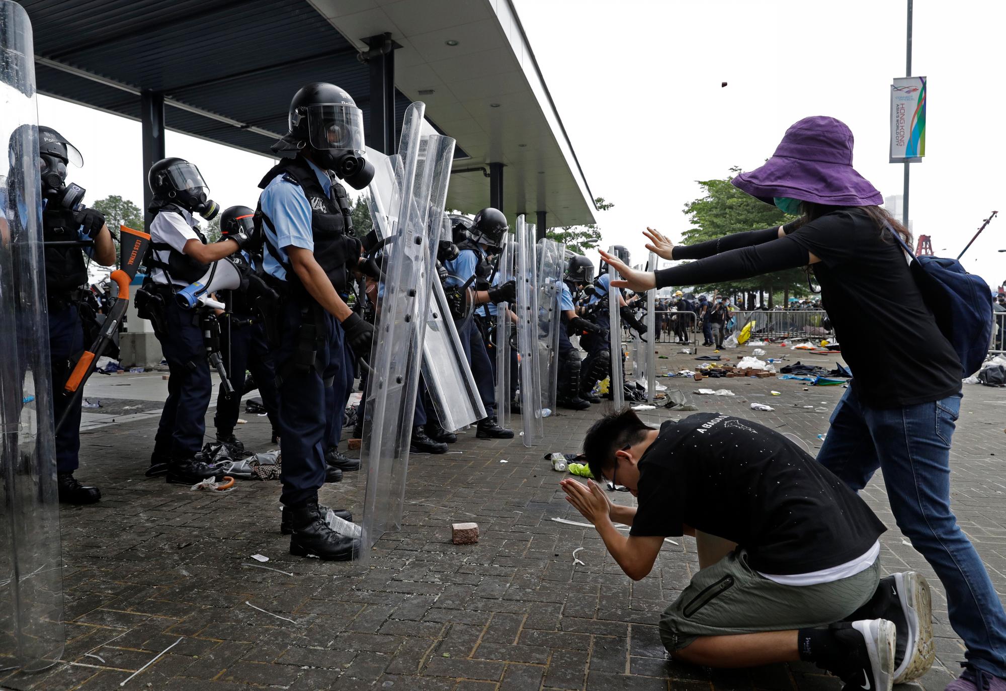 Un manifestante se inclina ante la policía antidisturbios después de que disparan gas lacrimógeno hacia manifestantes fuera del Consejo Legislativo en Hong Kong, el miércoles 12 de junio de 2019. 