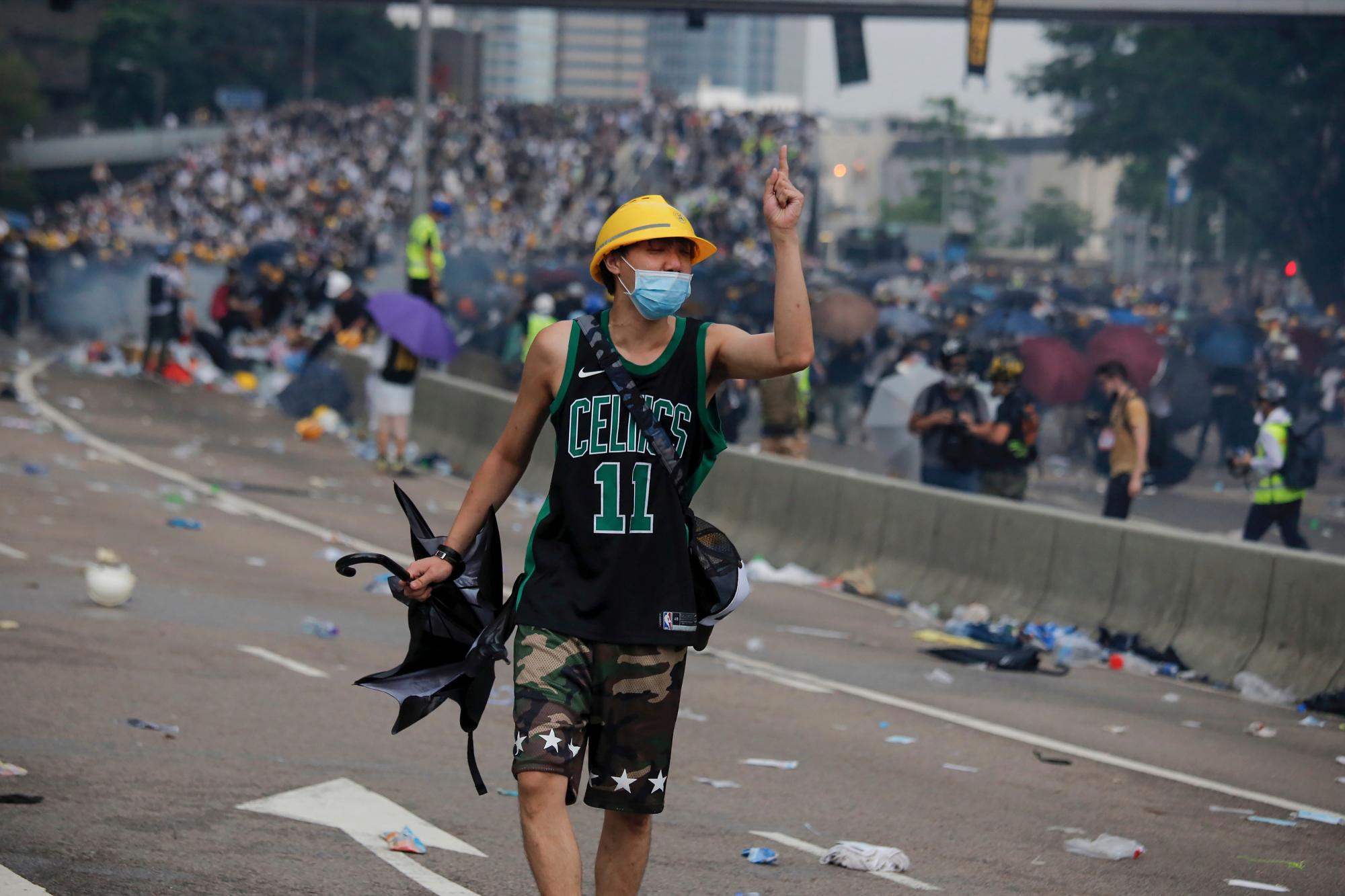 Un manifestante hace gestos en enfrentamientos con la policía antidisturbios durante una manifestación masiva frente al Consejo Legislativo en Hong Kong, el miércoles 12 de junio de 2019.