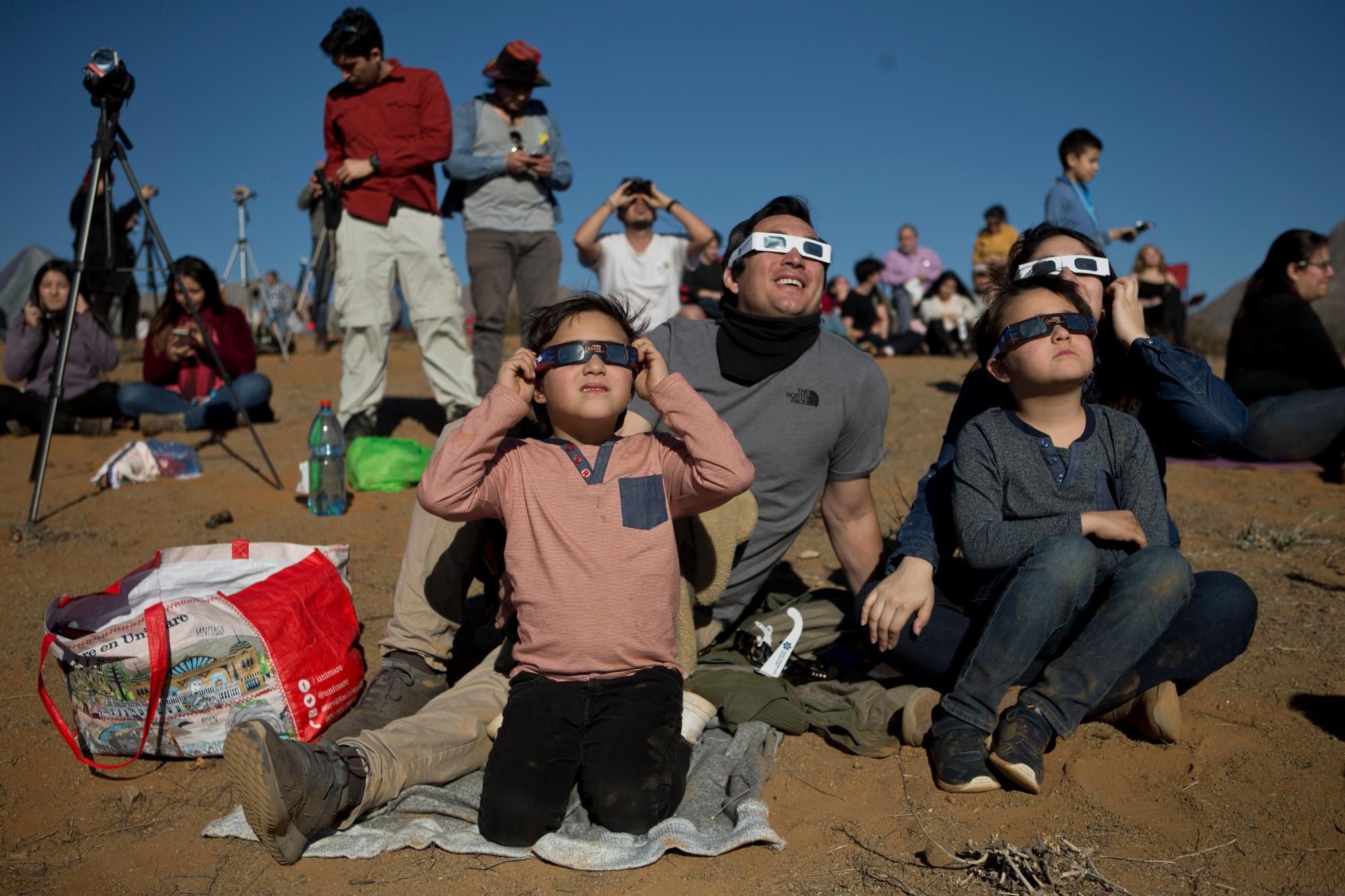 La gente ve un eclipse total de sol en La Higuera, Chile, el martes 2 de julio de 2019. Decenas de miles de turistas y lugareños miraron hacia el cielo este martes, cuando un raro eclipse total de sol comenzó a oscurecer los cielos en el norte de Chile.