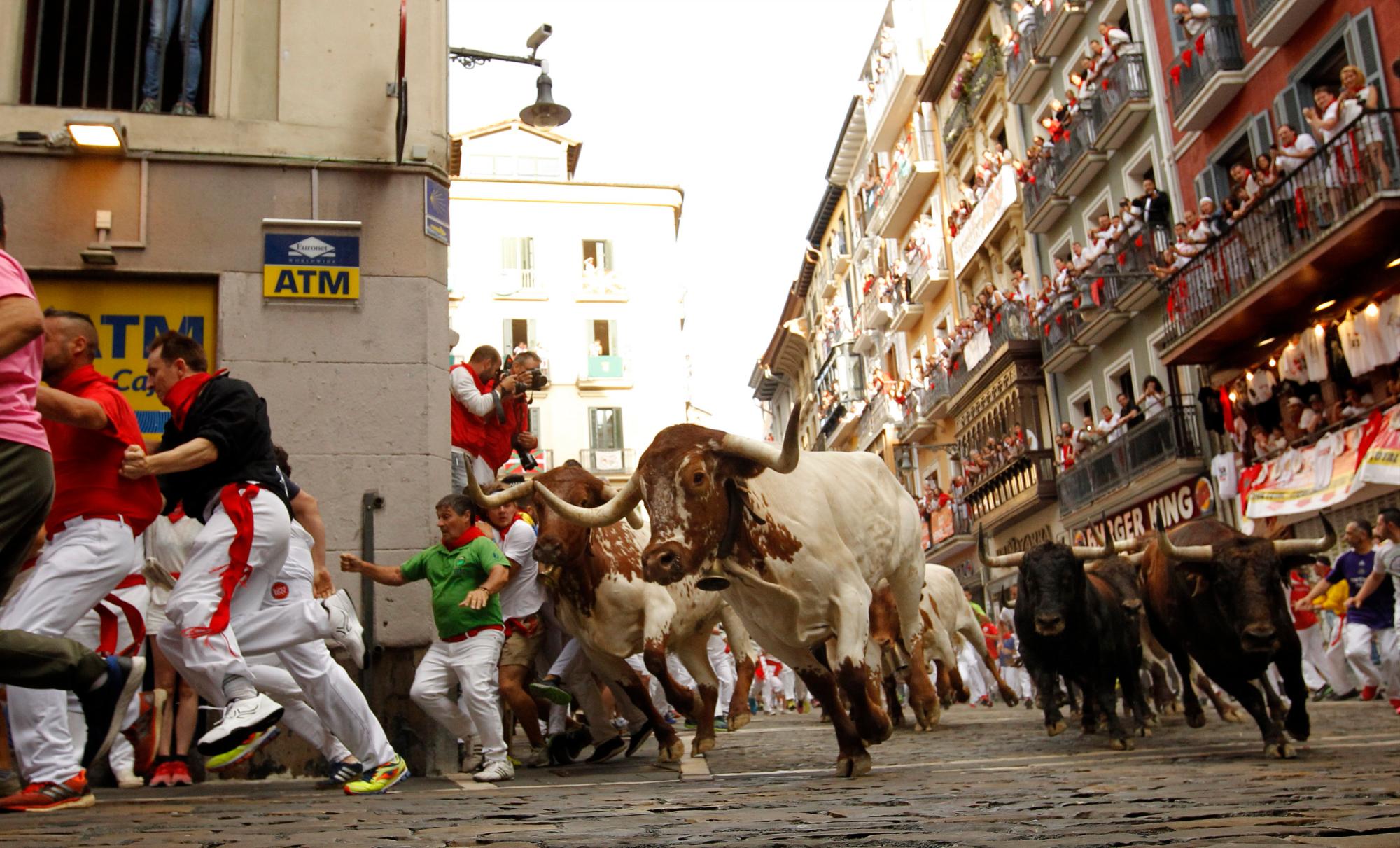 Los juerguistas corren al lado de los toros de combate del rancho Cebada Gago, durante la fuga de los toros en el Festival de San Fermín, en Pamplona, norte de España, el lunes 8 de julio de 2019. Los chiflados de todo el mundo viajan a Pamplona cada año para participar. Los ocho días de la corrida de los toros.