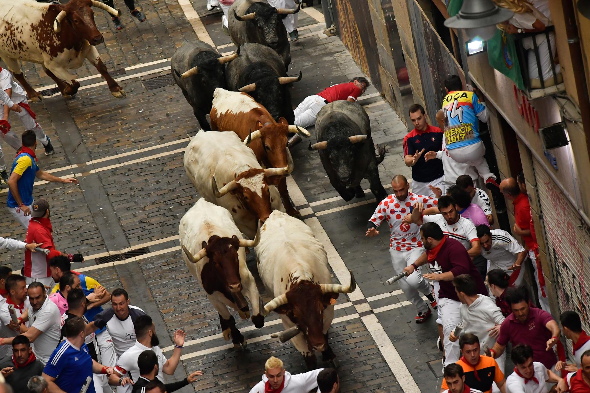 Los juerguistas corren al lado de los toros de toros durante la corrida de los toros en el Festival de San Fermín, en Pamplona, norte de España, el martes 9 de julio de 2019. Los juerguistas de todo el mundo acuden a Pamplona cada año para participar en los ocho días del corrida de toros.