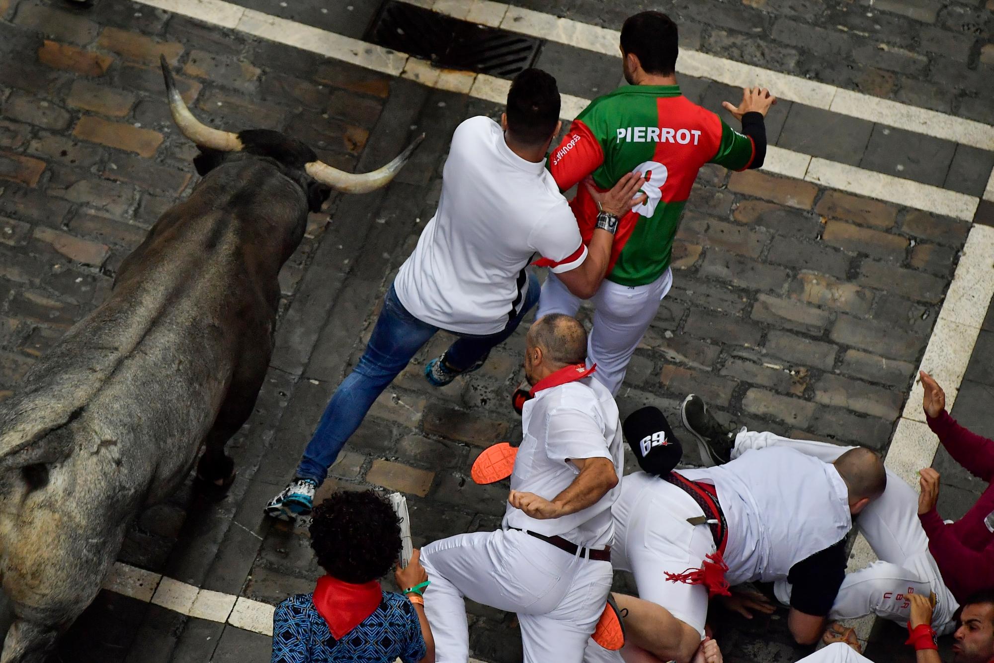 Los juerguistas corren al lado de los toros de toros durante la corrida de los toros en el Festival de San Fermín, en Pamplona, norte de España, el martes 9 de julio de 2019. Los juerguistas de todo el mundo acuden a Pamplona cada año para participar en los ocho días del corrida de toros. 