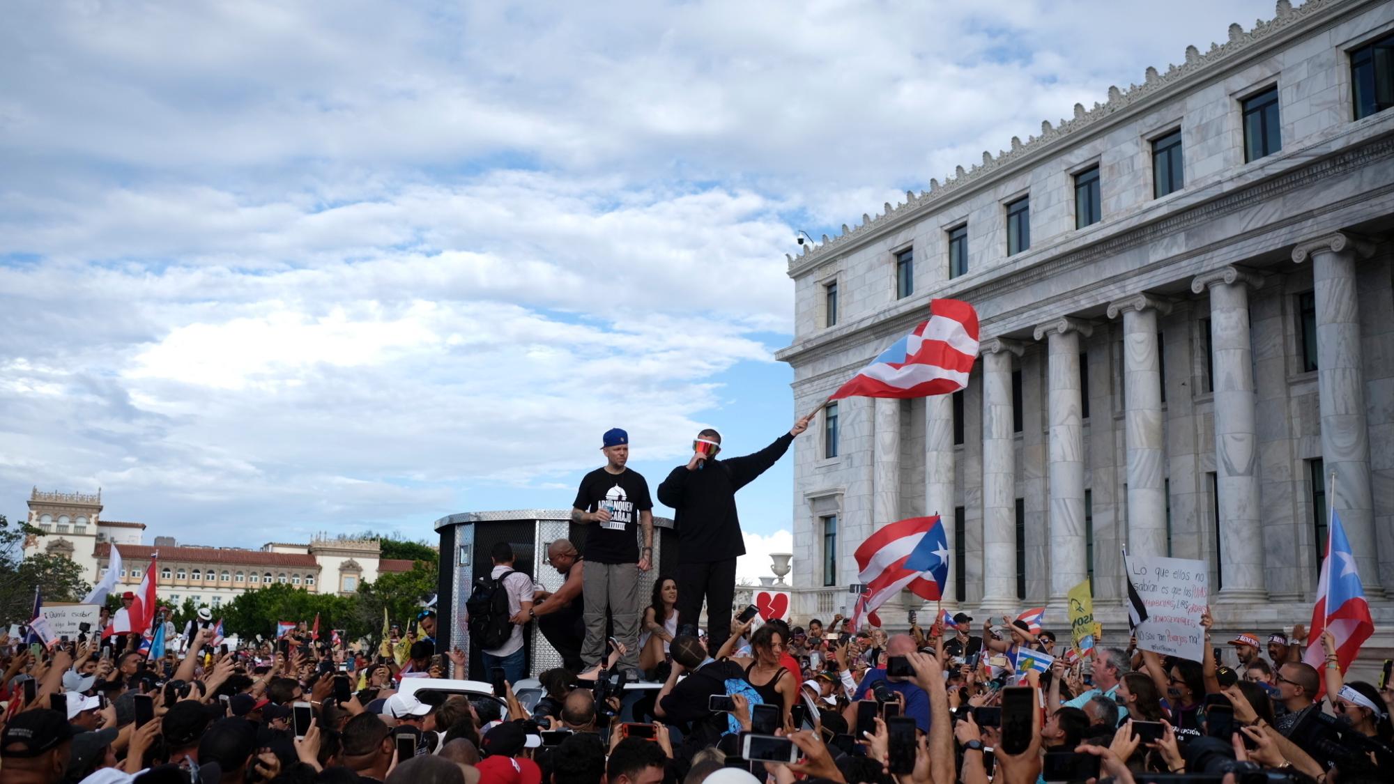 Los artistas puertorriqueños René Pérez “Residente” y Benito Antonio Martinez Ocasio “Bad Bunny” avivan a una multitud frente al capitolio puertorriqueño previo a una manifestación contra el gobernador Ricardo Rosselló, en San Juan, Puerto Rico, el miércoles 17 de julio de 2019. 