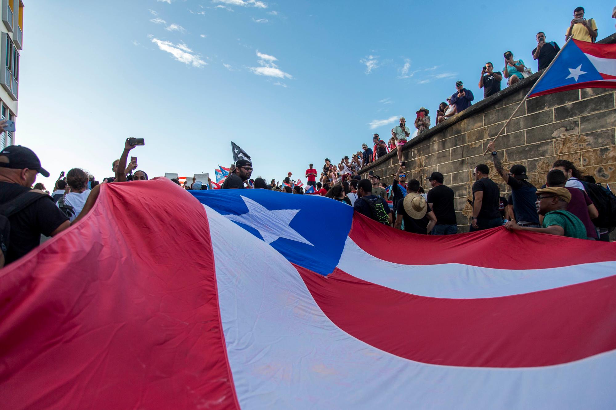 Manifestantes que realizan una gigantesca marcha de la bandera de Puerto Rico contra el gobernador Ricardo Rosselló, en San Juan, Puerto Rico, el miércoles 17 de julio de 2019.