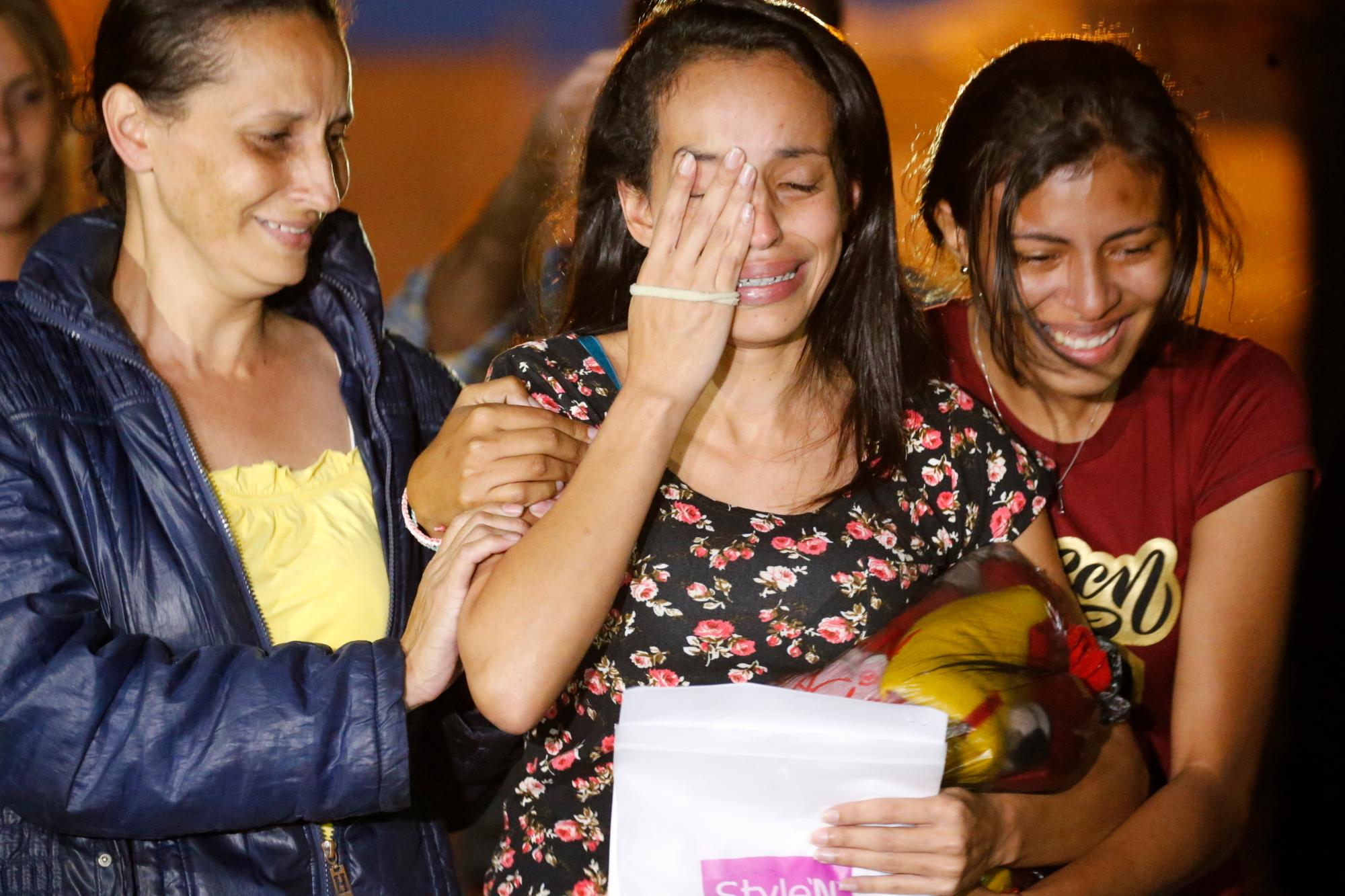 En esta fotografía´del martes 16 de julio de 2019, Karen Palacios, al centro, es ayudada por familiares después de que salió de la cárcel en Los Teques en las afueras de Caracas, Venezuela. Palacios, que toca el clarinete y fue despedida de la Filarmónica Nacional por criticar al gobierno, estuvo detenida 6 semanas. 