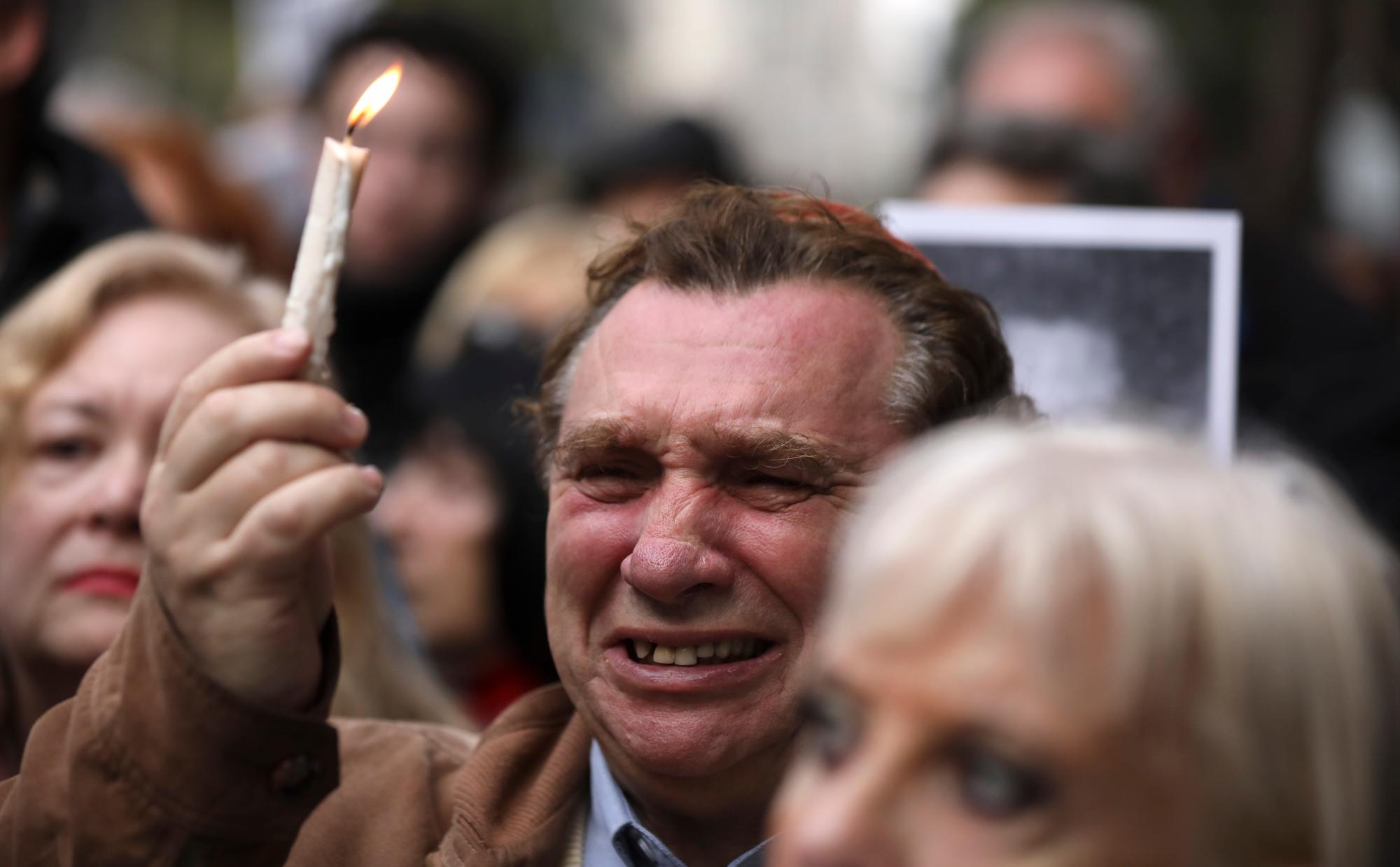 En esta fotografía del jueves 18 de julio de 2019, un hombre llora mientras sostiene una vela en el 25to aniversario del atentado contra el centro judío AMIA en el que murieron 85 personas en Buenos Aires, Argentina. 