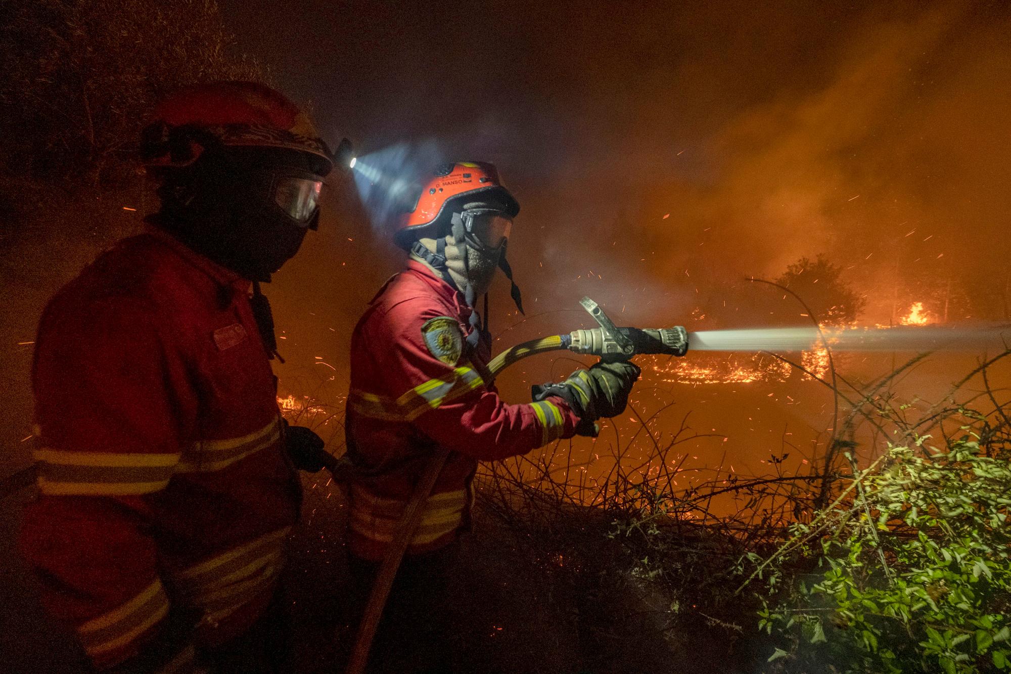 Los bomberos intentan apagar un incendio forestal cerca de la aldea de Cardigos, en el centro de Portugal, el domingo 21 de julio de 2019. Unos 1.800 bomberos luchaban por contener los incendios en el centro de Portugal que ya han herido a personas, incluidos varios bomberos, dijeron las autoridades el domingo. 