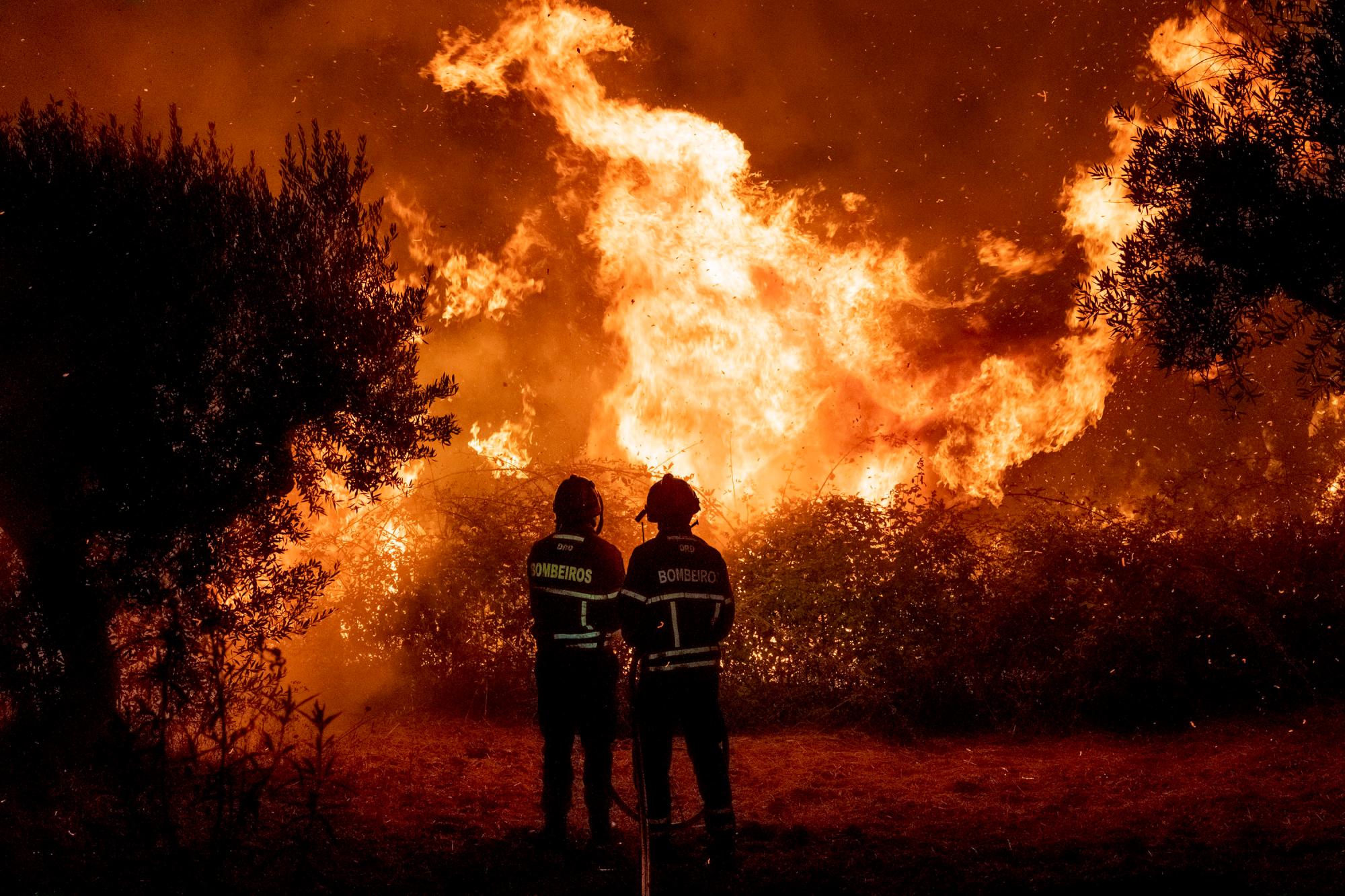 Los combatientes intentan apagar un incendio forestal cerca de la aldea de Cardigos, en el centro de Portugal, el domingo 21 de julio de 2019. Unos 1.800 bomberos luchaban por contener los incendios en el centro de Portugal que ya han herido a personas, incluidos varios bomberos, dijeron las autoridades el domingo.