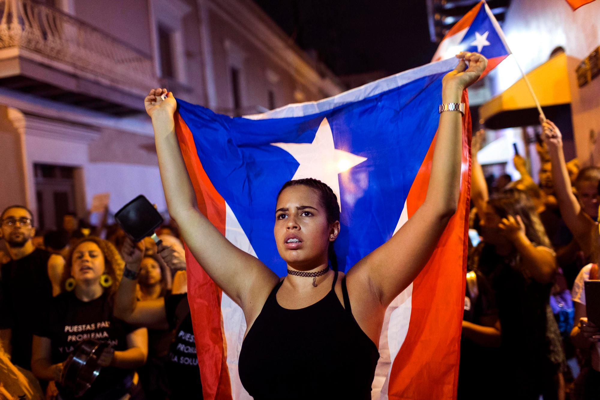Un manifestante con una bandera puertorriqueña protesta contra el gobernador Ricardo Rosselló en San Juan, Puerto Rico, el martes 23 de julio de 2019. Los manifestantes exigen que Rossello renuncie a su participación en una charla privada en la que usó profanidades para describir a una ex concejala de la ciudad de Nueva York y una junta de control federal que supervisa las finanzas de la isla al aire libre.