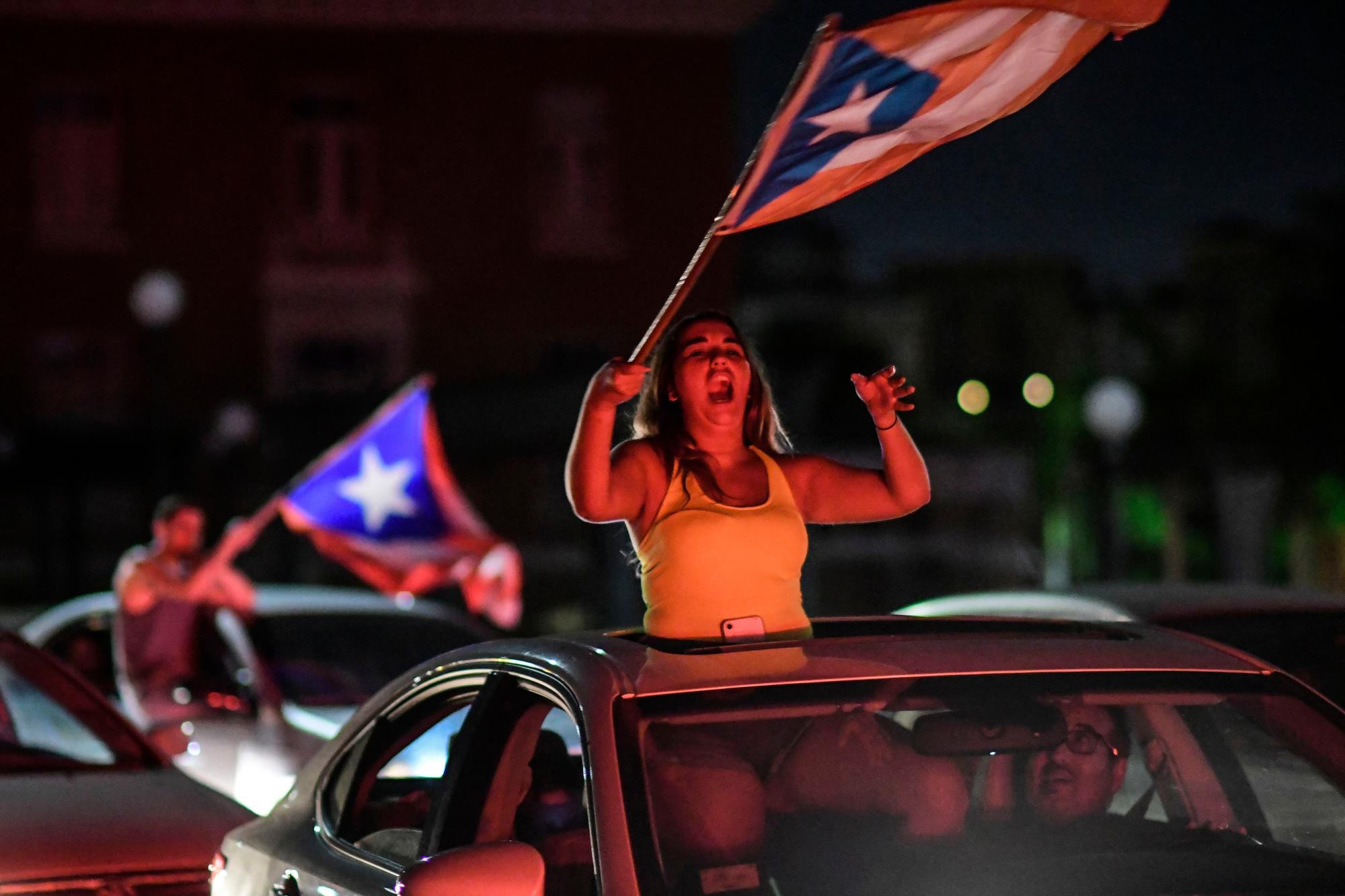La gente celebra, luego de que el gobernador Ricardo Rosselló anunció que renunciará el 2 de agosto luego de casi dos semanas de protestas y agitación política provocada por una filtración de mensajes de chat crudos e insultantes entre él y sus principales asesores en San Juan, Puerto Rico, el jueves. , 25 de julio de 2019. 