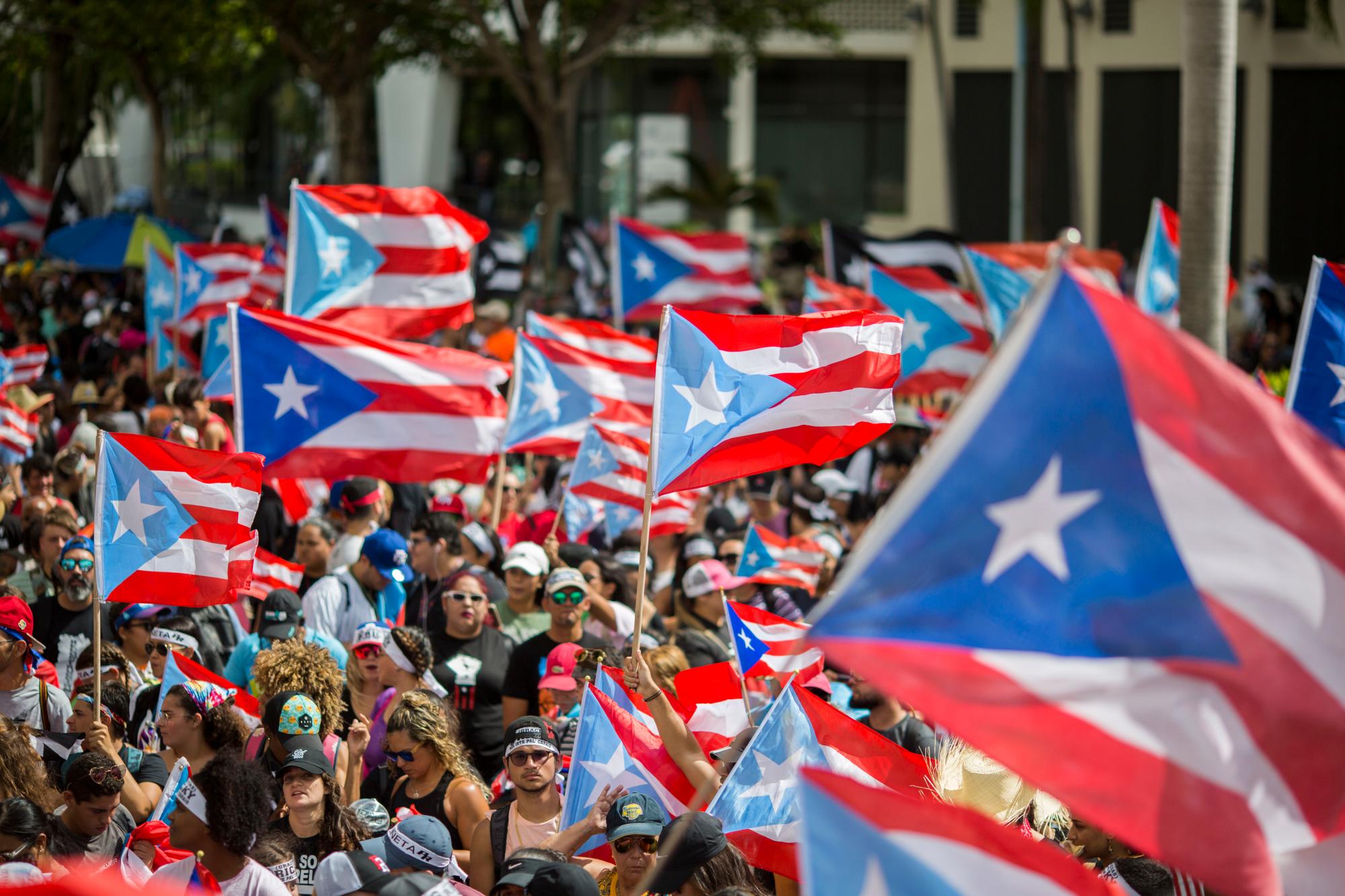 La gente se reúne para celebrar la renuncia del gobernador Ricardo Rosselló, quien anunció durante la noche que renunciará el 2 de agosto luego de semanas de protestas por charlas en línea obscenas y misóginas y filtradas, en San Juan, Puerto Rico, el jueves 25 de julio de 2019. 