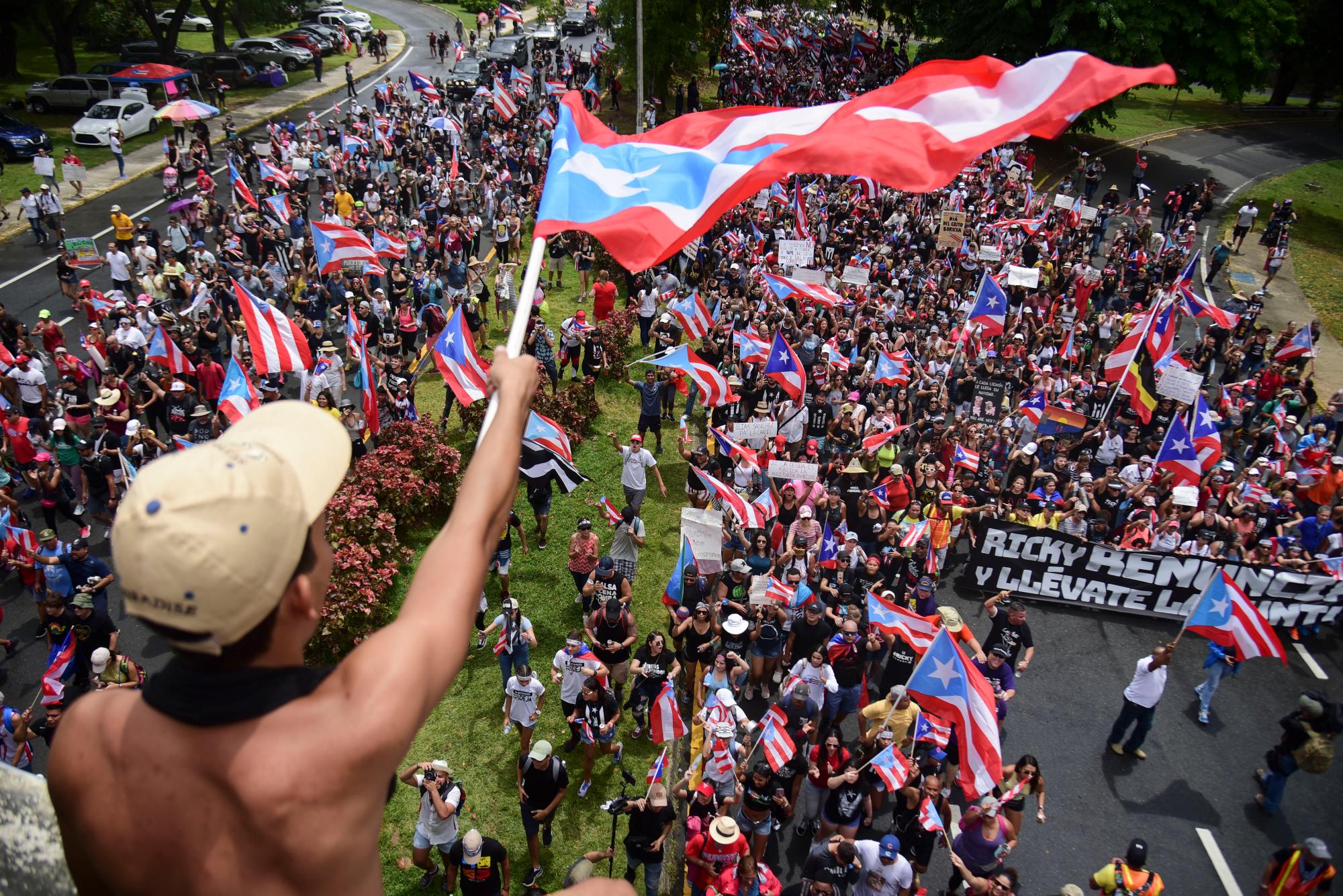 Cientos de personas marchan para celebrar la renuncia del gobernador Ricardo Rossello, quien anunció durante la noche que renunciará el 2 de agosto luego de semanas de protestas por chats en línea obscenos y misóginos, en San Juan, Puerto Rico, el jueves 25 de julio de 2019. 