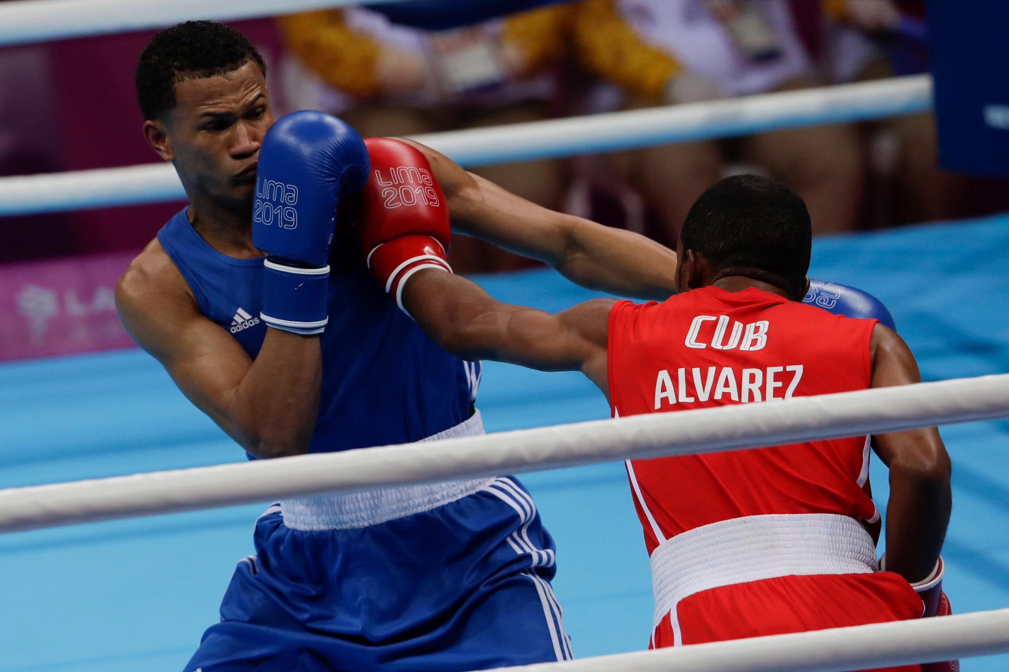 El dominicano Leonel de los Santos, a la izquierda, recibe un golpe del cubano Lázaro Álvarez en la pelea final masculina de 60 kg en los Juegos Panamericanos en Lima, Perú, el jueves 1 de agosto de 2019. Álvarez ganó la medalla de oro. 