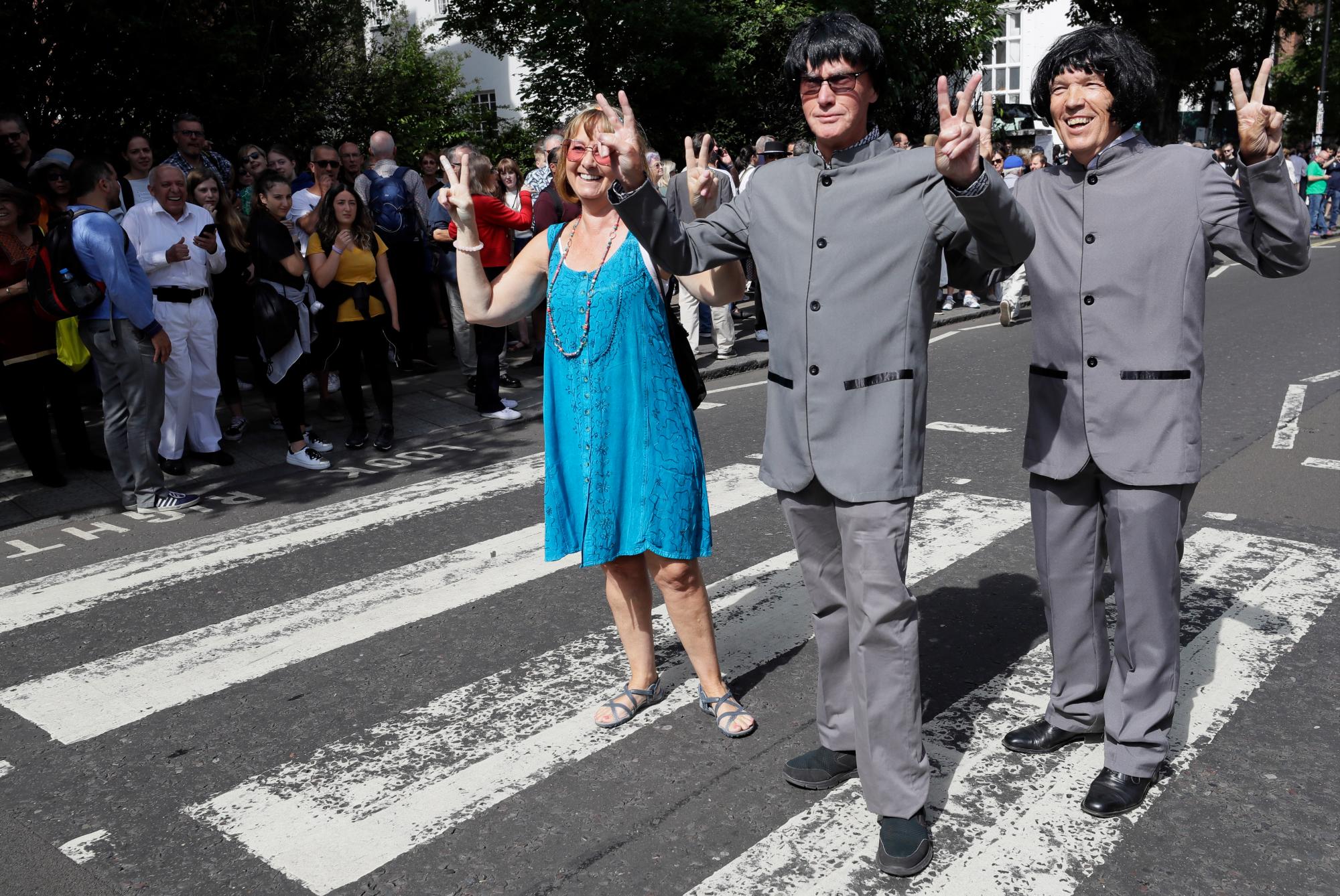 Los fanáticos posan para una fotografía mientras miles de fanáticos se reúnen para caminar a través del paso de cebra de Abbey Road, en el 50 aniversario de los músicos pop británicos The Beatles haciéndolo para la portada de su álbum ‘Abbey Road’ en St Johns Wood en Londres, el jueves. 8 de agosto de 2019. Su objetivo era cruzar 50 años al minuto desde que los ‘Fab Four’ fueron fotografiados para el álbum. 
