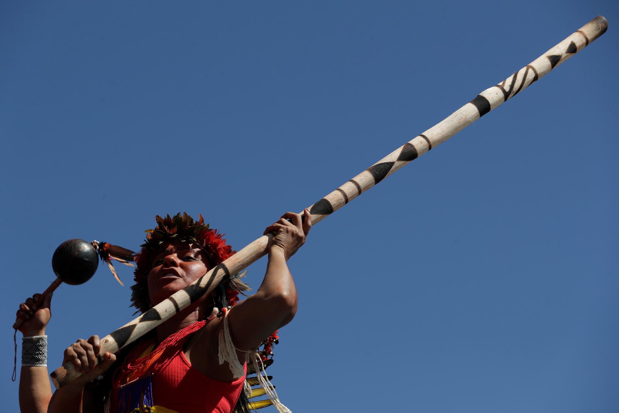 Una mujer indígena porta un arma tradicional durante una Marcha de Mujeres Indígenas, en Brasilia, Brasil, el martes 13 de agosto de 2019. Cientos de mujeres indígenas llegaron a la capital de Brasil para protestar por las políticas del presidente Jair Bolsonaro.