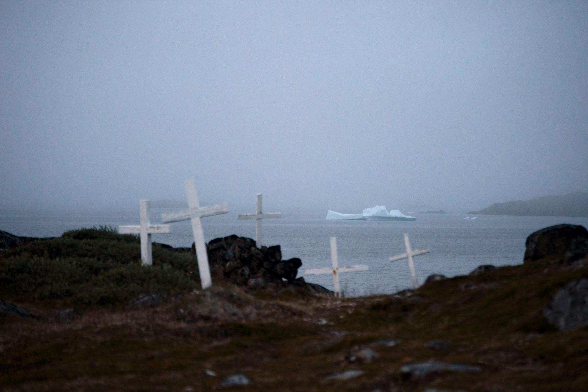 Un iceberg flota cerca de un cementerio en Kulusuk, Groenlandia, temprano el jueves 15 de agosto de 2019. Groenlandia se ha derretido más rápido en la última década y este verano, ha visto dos de los derretimientos más grandes registrados desde 2012. 