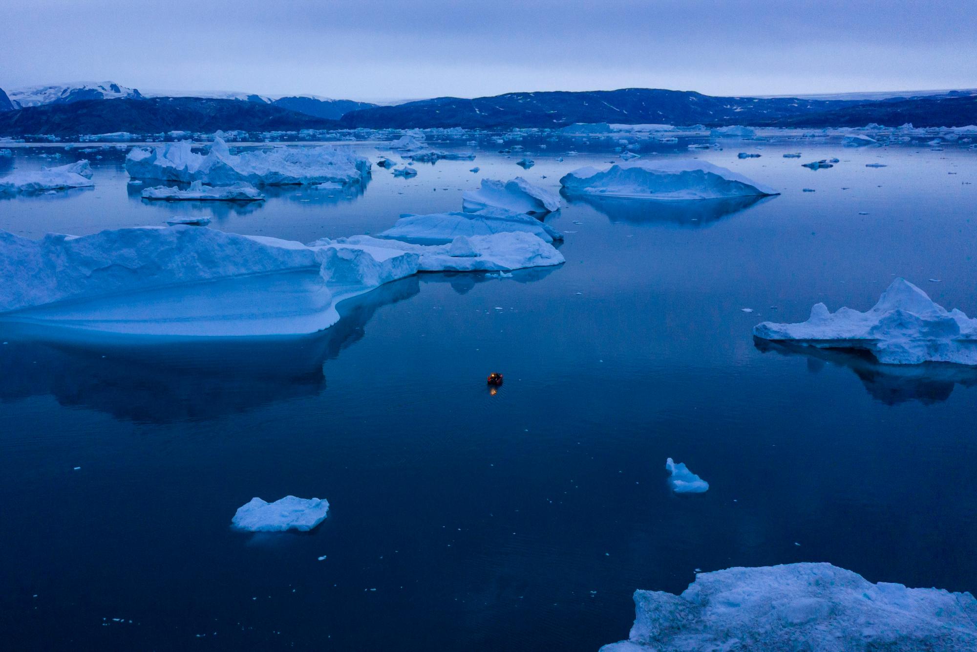 Un barco navega por la noche entre icebergs en el este de Groenlandia, a última hora del viernes 15 de agosto de 2019. Groenlandia se ha derretido más rápido en la última década y este verano, ha visto dos de los derretimientos más grandes registrados desde 2012. (Foto AP / Felipe Dana)