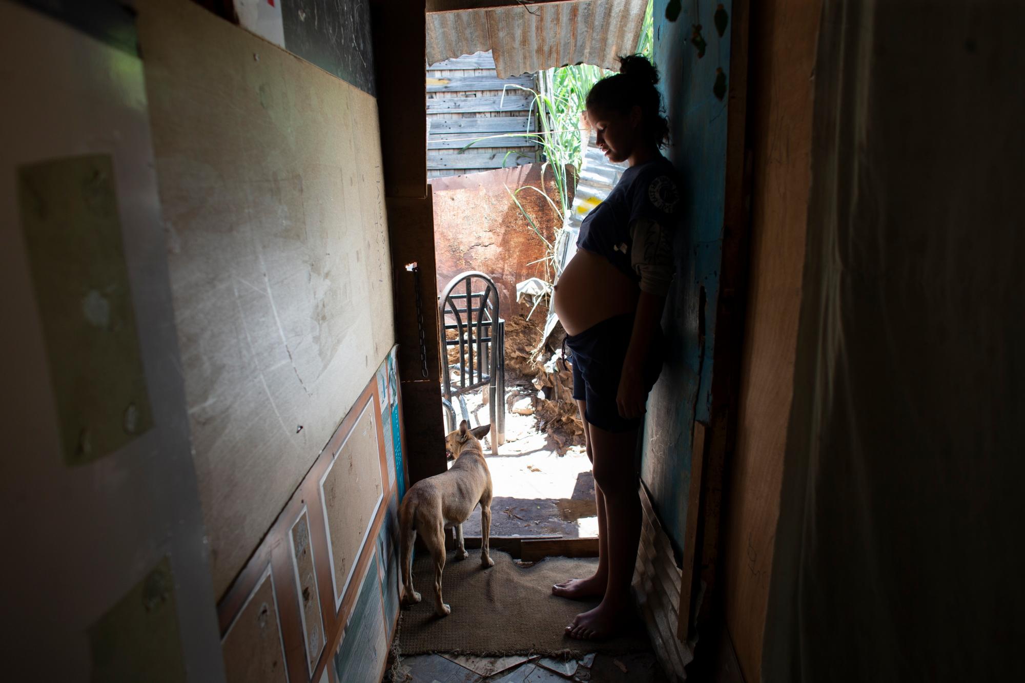 En esta foto tomada el 5 de agosto de 2019, Rosibeth Vargas, de 14 años, que está embarazada de siete meses, se encuentra dentro de su casa donde vive con sus padres, su hermana y sobrino de 18 años, en el área de Tablitas del Barrio de Caucaguita en las afueras de Caracas, Venezuela. Vargas dijo que su escuela permite que las madres estudiantes traigan a sus hijos a clase, pero que la abandonó después de ser intimidada. 