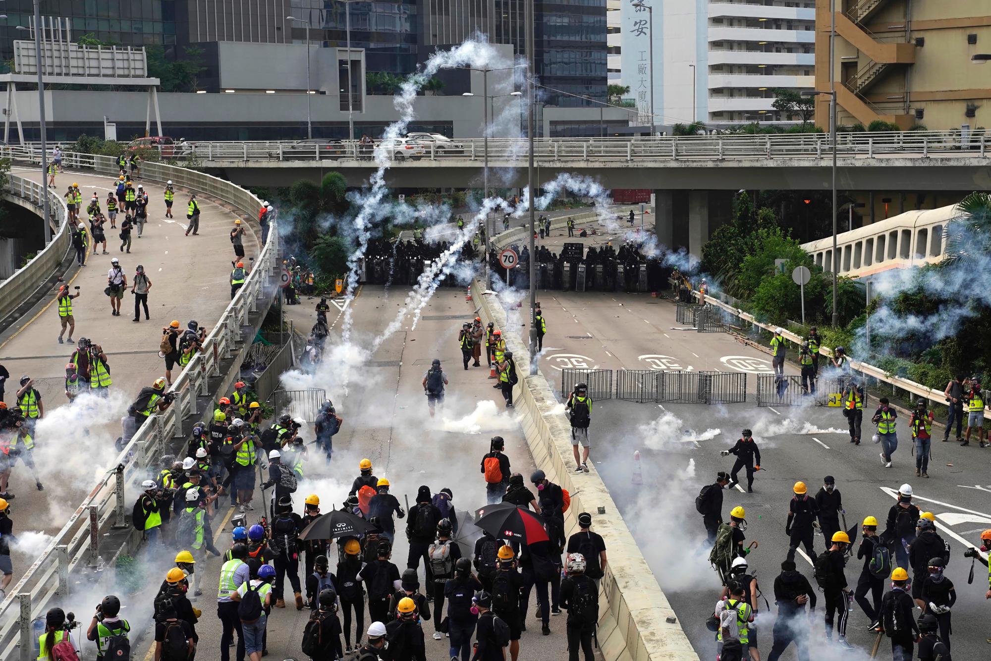 Las nubes de humo se elevan desde los botes de gas lacrimógeno mientras la policía y los manifestantes se enfrentan durante una protesta en Hong Kong, el sábado 24 de agosto de 2019. Los manifestantes de Hong Kong se enfrentaron con la policía el sábado cuando las escenas caóticas volvieron a las protestas de verano por primera vez. En más de una semana. 