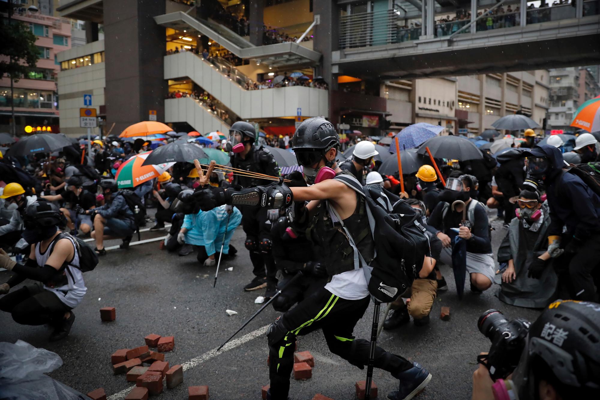 Un manifestante dispara un tiro de honda hacia las líneas policiales durante una protesta en Hong Kong, el domingo 25 de agosto de 2019. La policía se enfrenta con los manifestantes en Hong Kong por segundo día consecutivo el domingo después de una marcha a favor de la democracia en un distrito periférico. 