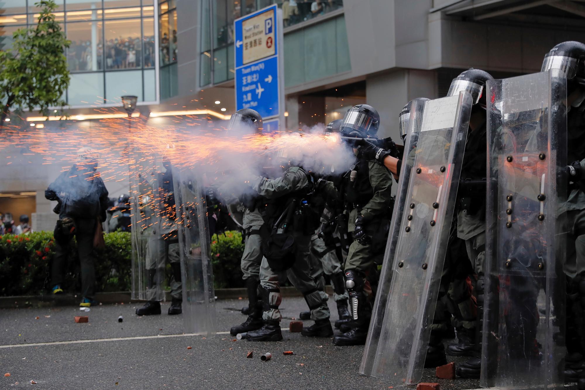La policía antidisturbios disparó gases lacrimógenos contra los manifestantes durante una protesta en Hong Kong, el domingo 25 de agosto de 2019. La policía de Hong Kong lanzó camiones de cañones de agua por primera vez en las protestas a favor de la democracia de este verano. Los dos camiones avanzaron con los agentes antidisturbios el domingo por la noche mientras empujaban a los manifestantes a lo largo de una calle en el distrito periférico de Tsuen Wan. 