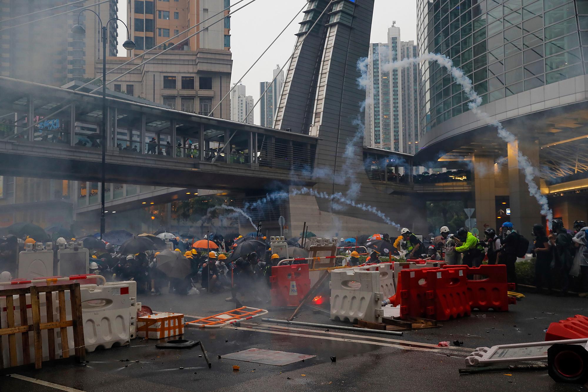 Los manifestantes se apresuran durante una protesta en Hong Kong, el domingo 25 de agosto de 2019. La policía de Hong Kong ha usado camiones de cañones de agua por primera vez en las protestas en favor de la democracia de este verano. Los dos camiones avanzaron con los agentes antidisturbios el domingo por la noche mientras empujaban a los manifestantes a lo largo de una calle en el distrito periférico de Tsuen Wan. 