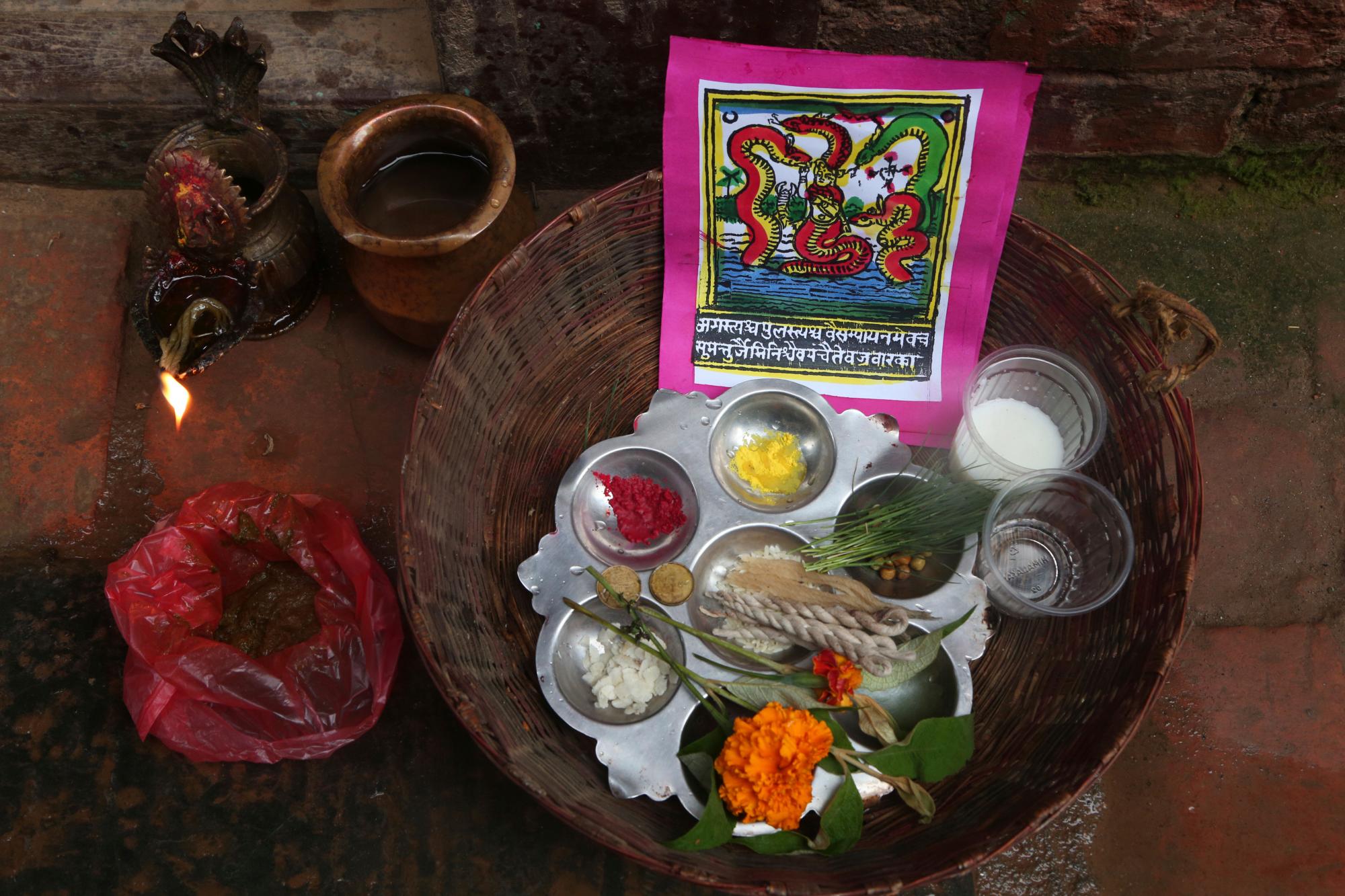 La foto del 5 de agosto de 2019 muestra una pintura tradicional en un canasto que contiene los materiales utilizados en los ritos del festival de Naag Panchami en Bhaktapur, Nepal. 