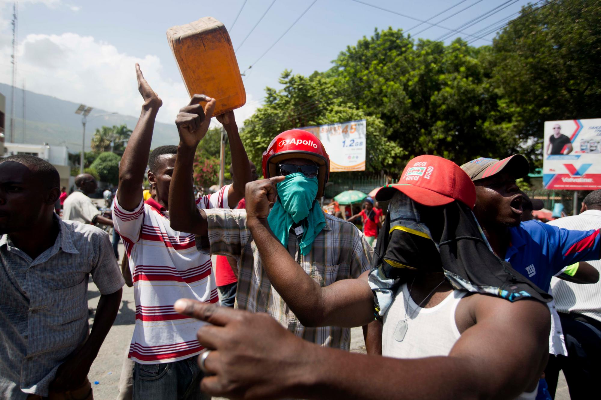 La gente protesta con contenedores de gas vacíos cerca de una estación de servicio durante una escasez de combustible en Puerto Príncipe, Haití, el lunes 2 de septiembre de 2019. Las estaciones han estado reduciendo sus horas de operación durante las últimas dos semanas, y el domingo todas las estaciones estaban cerradas. 