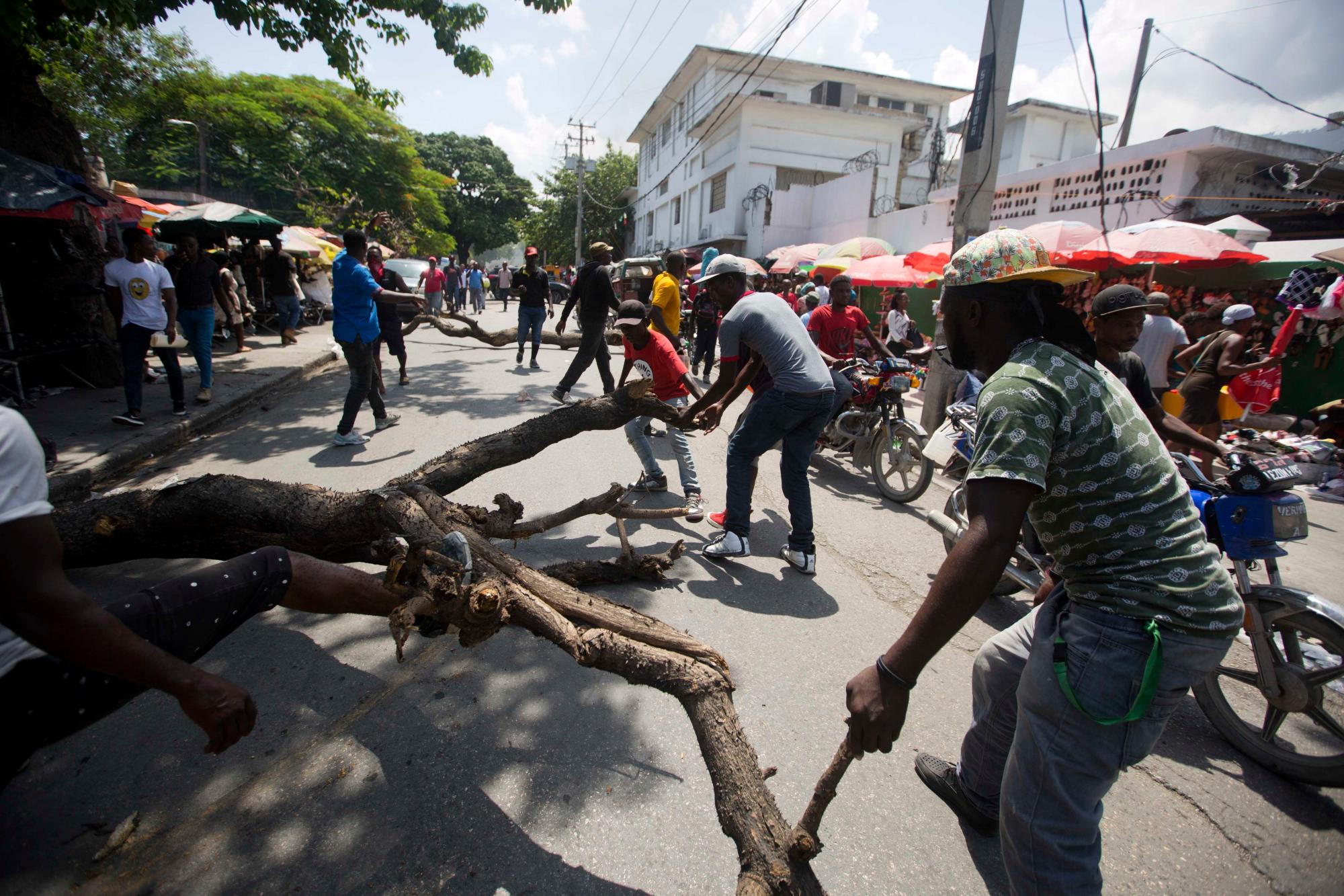 La gente bloquea una calle con un árbol para protestar por la escasez de combustible de dos semanas en Puerto Príncipe, Haití, el lunes 2 de septiembre de 2019. 