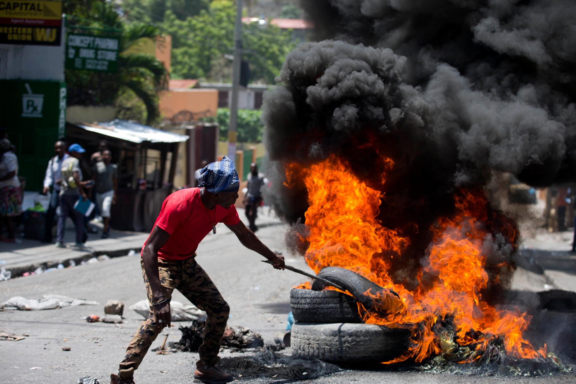 Un hombre quema neumáticos para protestar por una escasez de combustible de dos semanas en Puerto Príncipe, Haití, el lunes 2 de septiembre de 2019. 