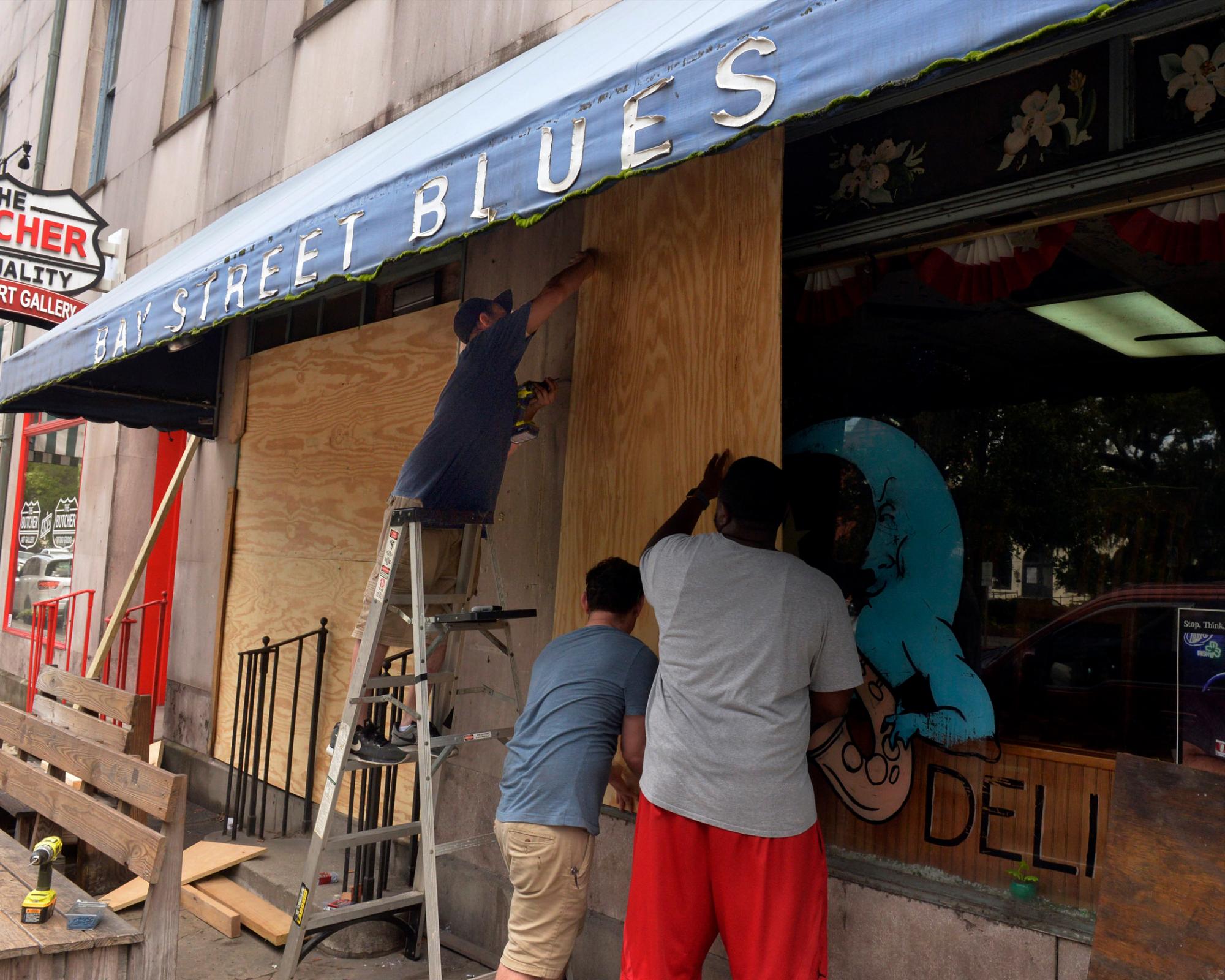 Los trabajadores abordan las ventanas de The Bay Street Blues en preparación de la posible llegada del huracán Dorian, el martes 3 de septiembre de 2019 en Savannah, Georgia 