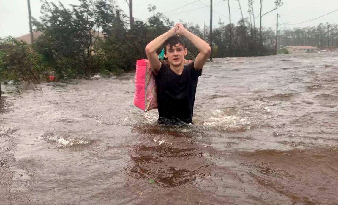 Matthew Aylen vadea por el agua hasta la cintura mientras es rescatado de su hogar inundado durante el huracán Dorian en Freeport, Bahamas, el martes 3 de septiembre de 2019. Prácticamente estacionándose sobre las Bahamas durante un día y medio, Dorian golpeó las islas el martes en un ataque que devastó miles de hogares, atrapó a personas en áticos y hospitales. 