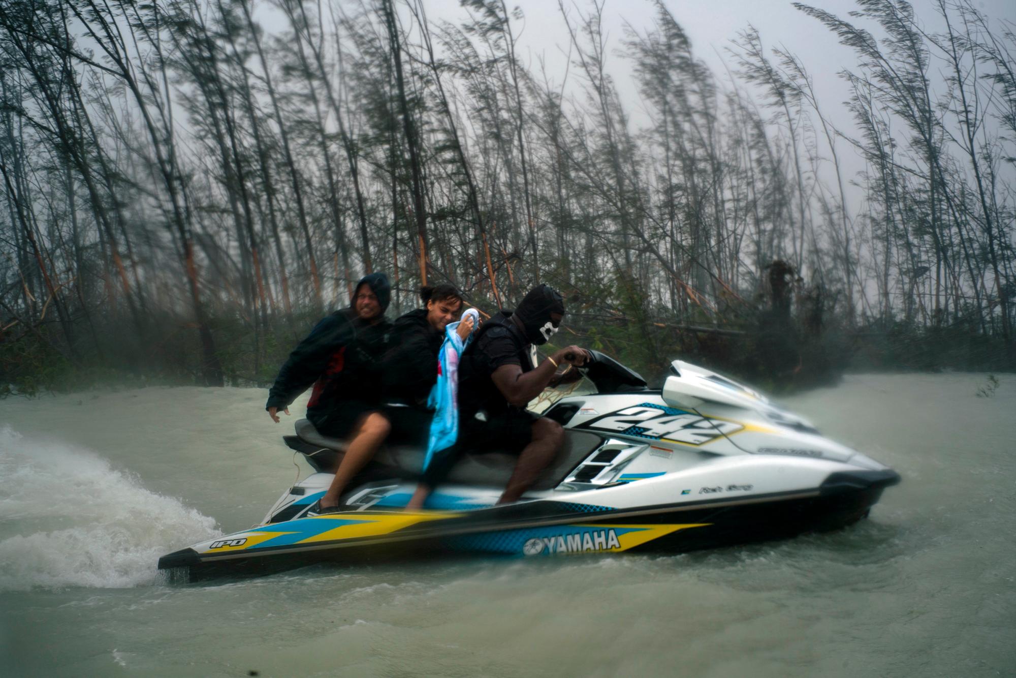 Una mujer que quedó atrapada por las inundaciones durante el huracán Dorian es transportada fuera del área por voluntarios en una moto de agua cerca del puente Causarina en Freeport, Gran Bahama, Bahamas, el martes 3 de septiembre de 2019. Los fuertes vientos de la tormenta y las inundaciones de lodo devastaron miles de hogares. 