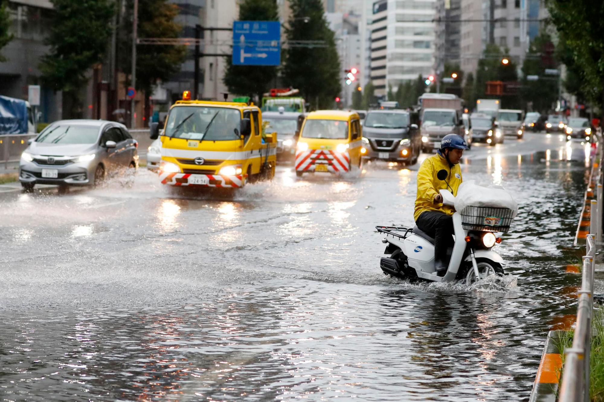 Un hombre viaja en un ciclomotor por una calle inundada debido a un tifón en Tokio el lunes 9 de septiembre de 2019. 