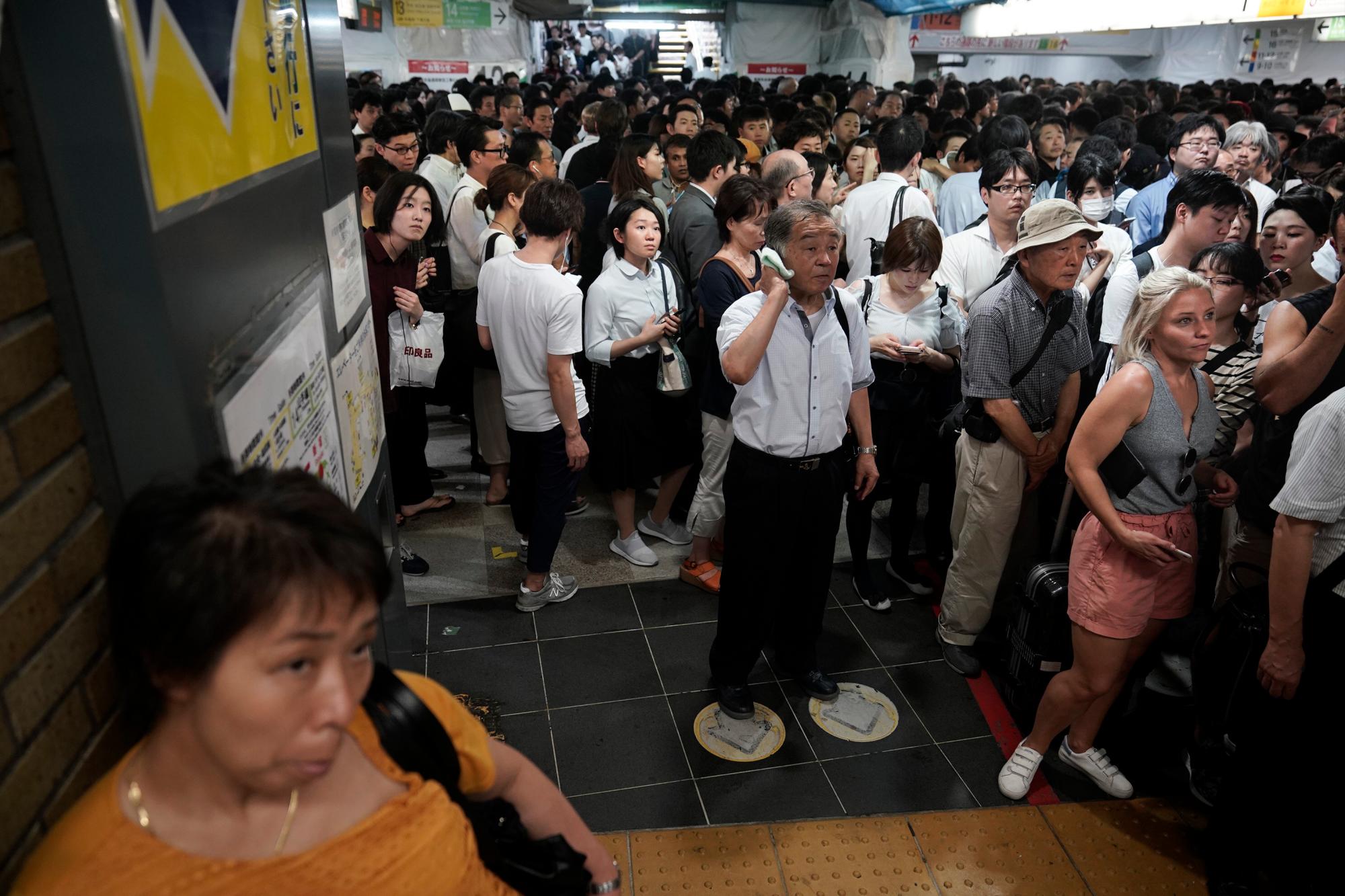 Los pasajeros se alinean en la estación Shinjuku, esperando que las plataformas de trenes abran el lunes 9 de septiembre de 2019 en Tokio. El tifón Faxai está soplando en el área metropolitana de Tokio, interrumpiendo los viajes, cortando el poder y causando docenas de lesiones.