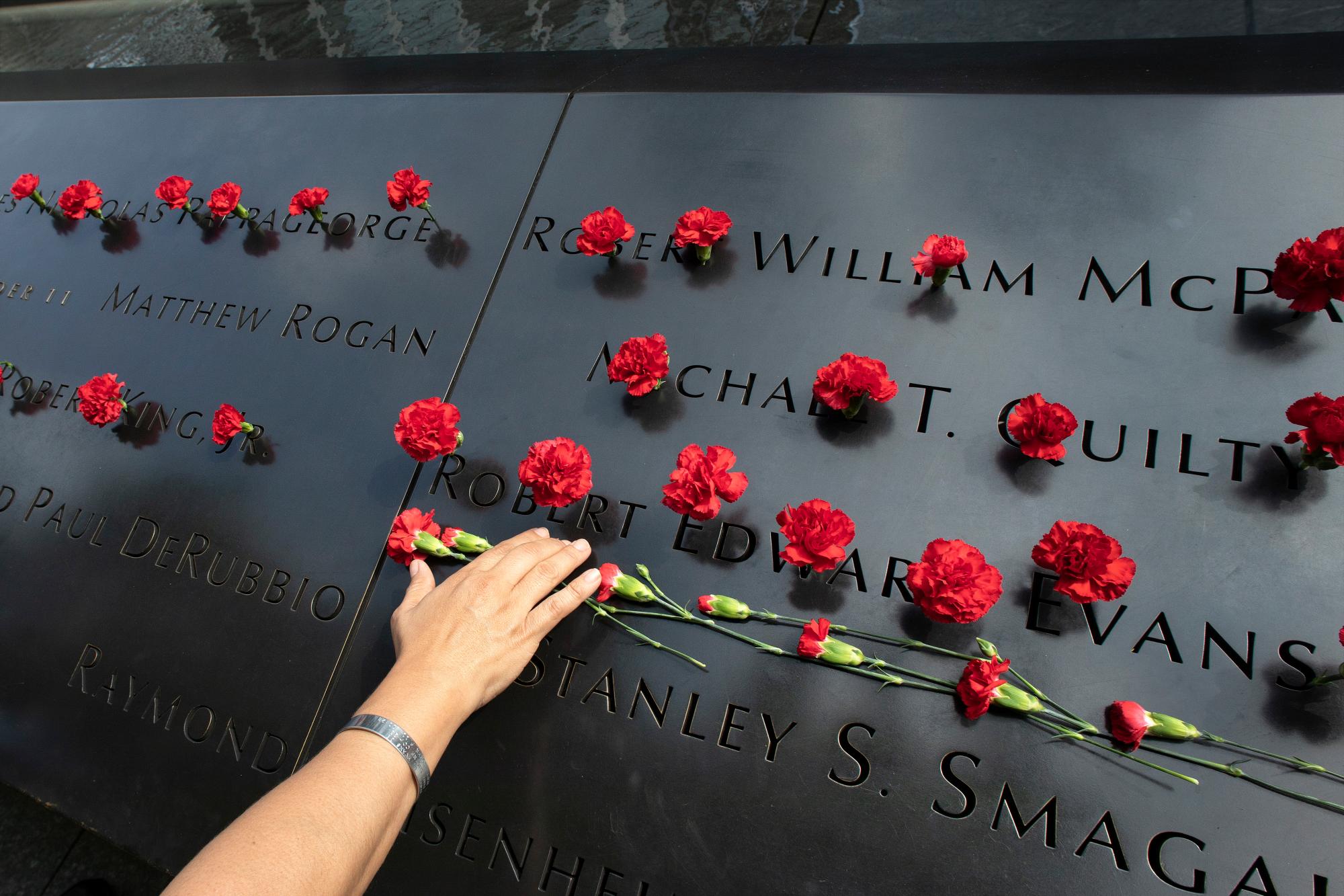 Norma Molina, de San Antonio, Texas, deja flores con los nombres de los bomberos de Engine 33 en el Memorial del 11 de septiembre, lunes 9 de septiembre de 2019, en Nueva York. Su novio Robert Edward Evans, miembro del Motor 33, fue asesinado en la torre norte del World Trade Center el 11 de septiembre de 2001. 