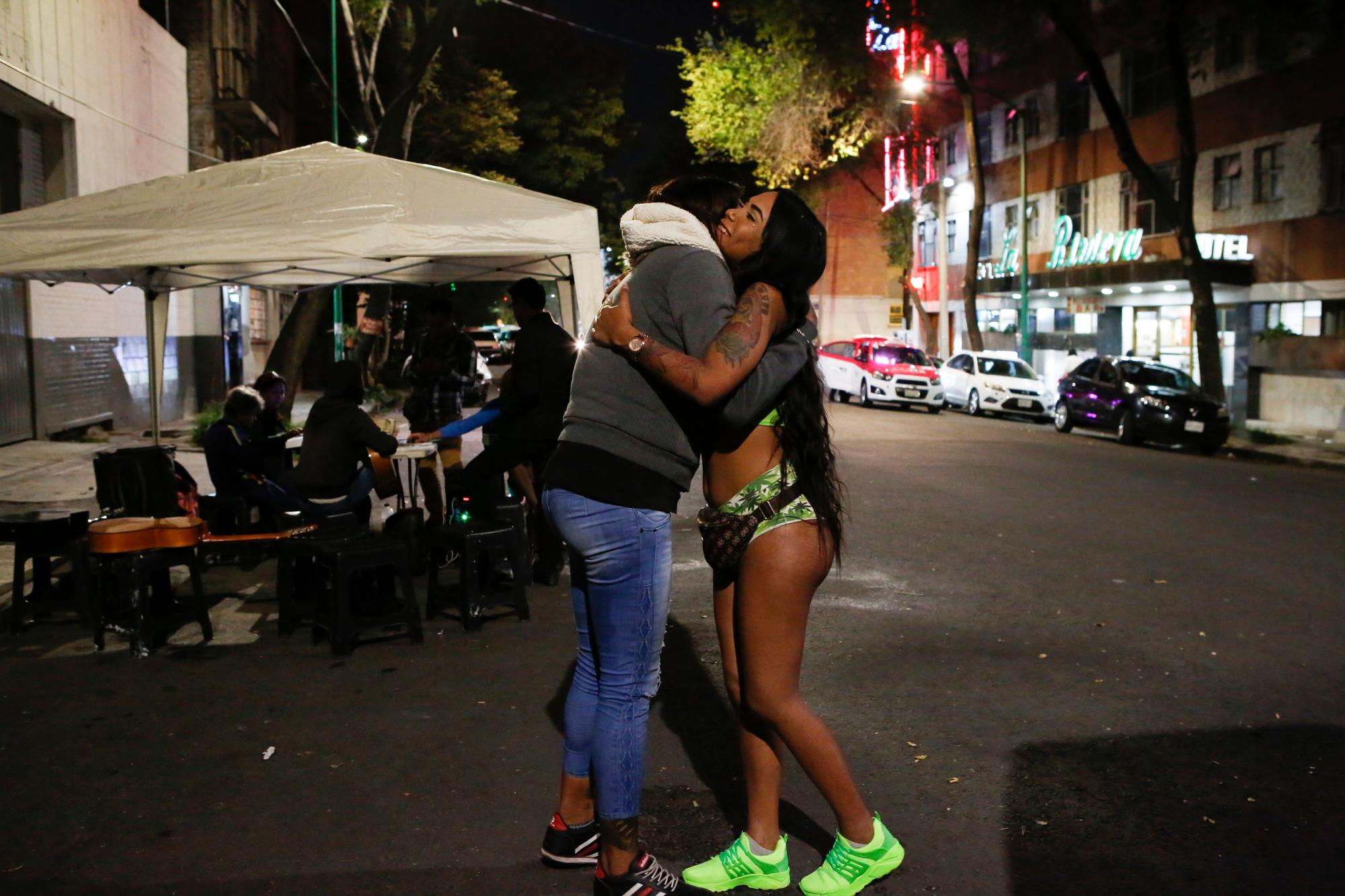 En esta foto del 28 de agosto de 2019, la activista de derechos trans Kenya Cuevas abraza a Angie, una trabajadora sexual transgénero de 20 años, en la Ciudad de México. Cuevas fundó la organización Casa de Muñecas, que promueve la protección de las mujeres trans. 