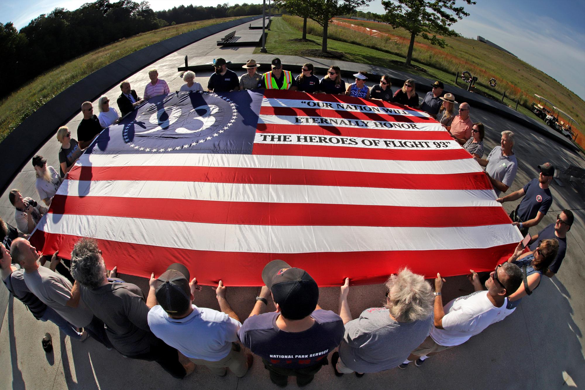 Los visitantes del Monumento Nacional del Vuelo 93 en Shanksville, Pensilvania, participan en un servicio conmemorativo al atardecer el martes 10 de septiembre de 2019, mientras la nación se prepara para conmemorar el 18 aniversario de los ataques del 11 de septiembre de 2001. 