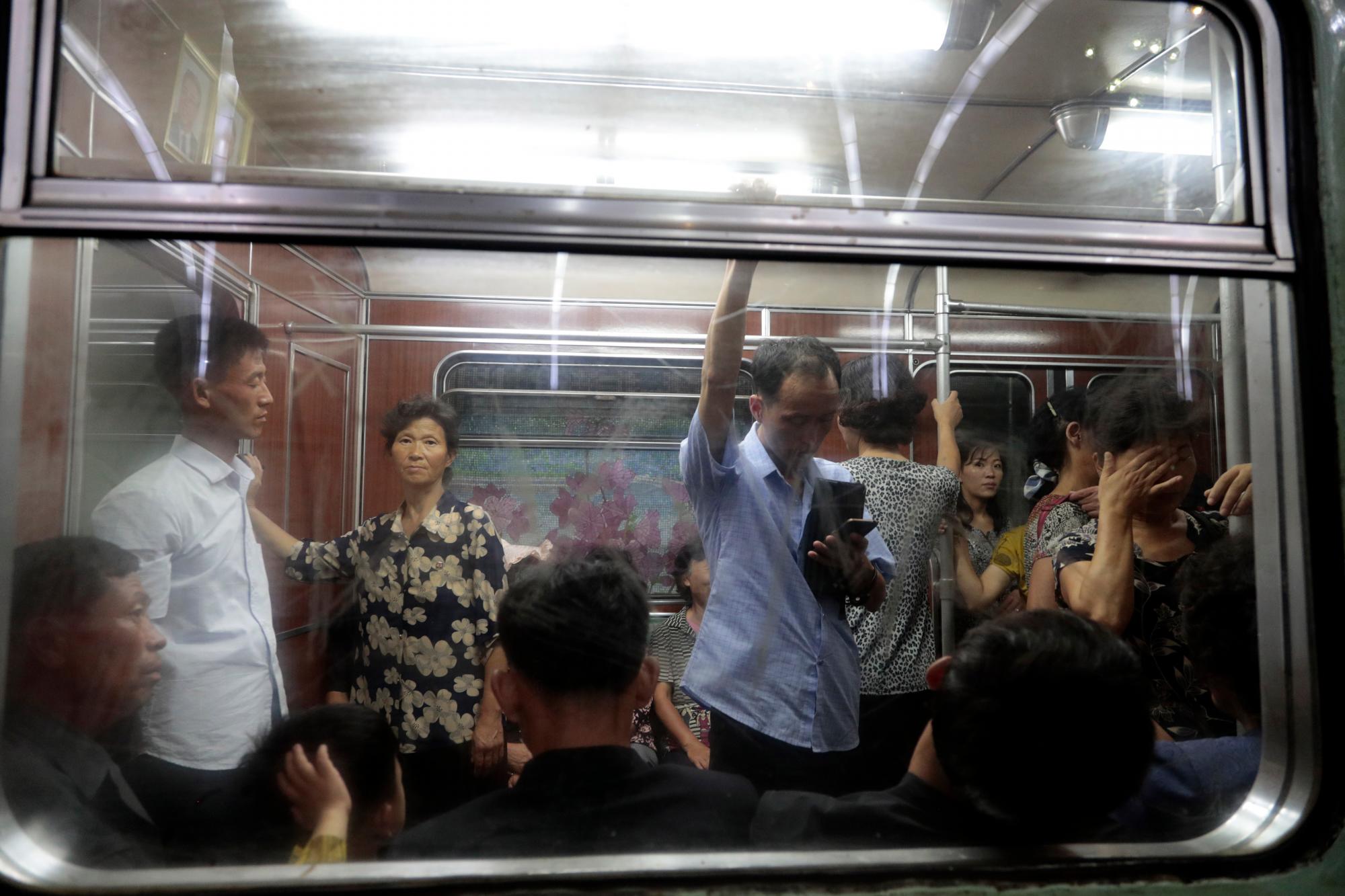 Passengers are seen through a carriage window riding a subway in Pyongyang, North Korea, Wednesday, Sept. 11, 2019. 
