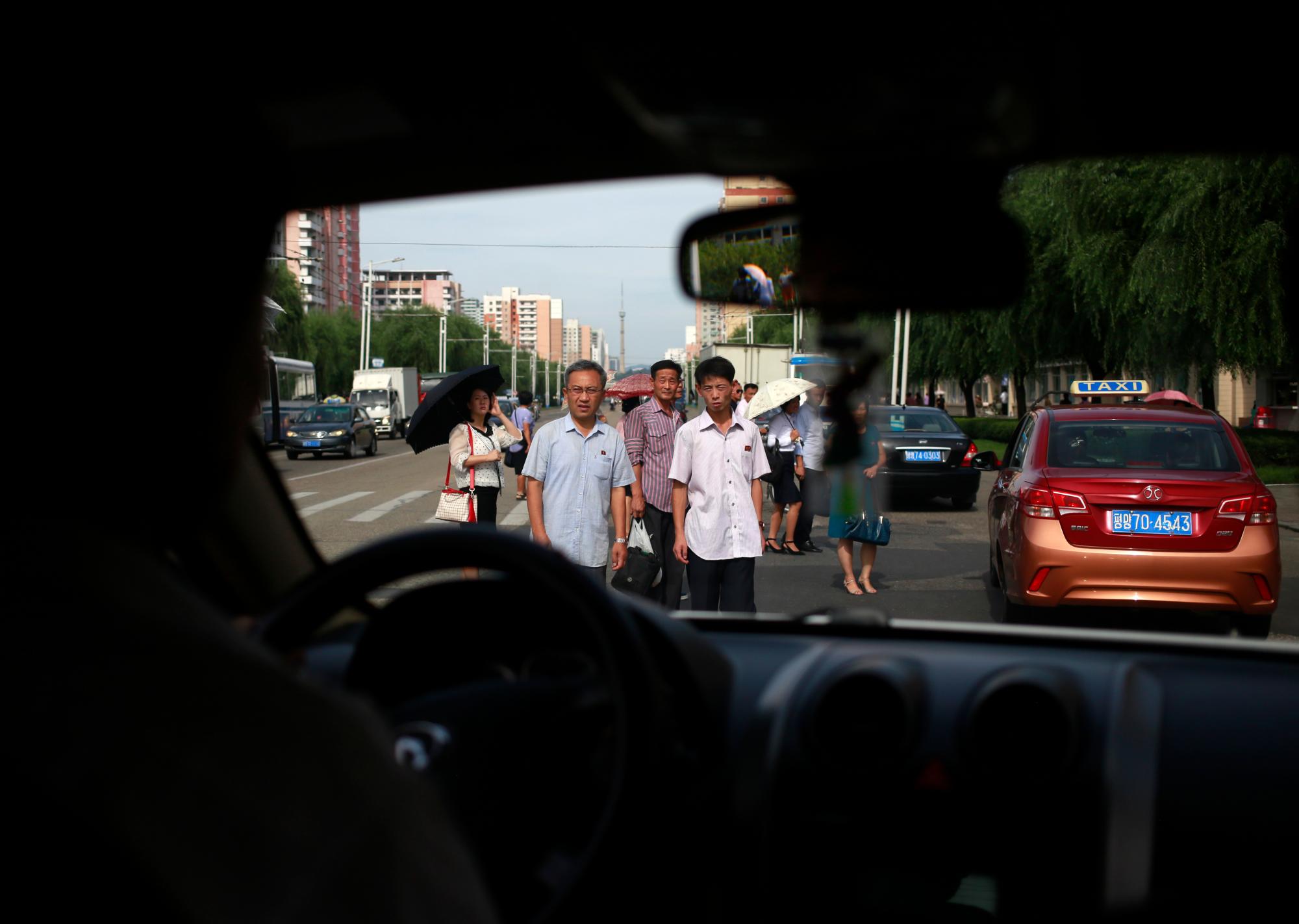 La gente cruza el tráfico en una calle principal en Pyongyang, Corea del Norte, el miércoles 11 de septiembre de 2019. 
